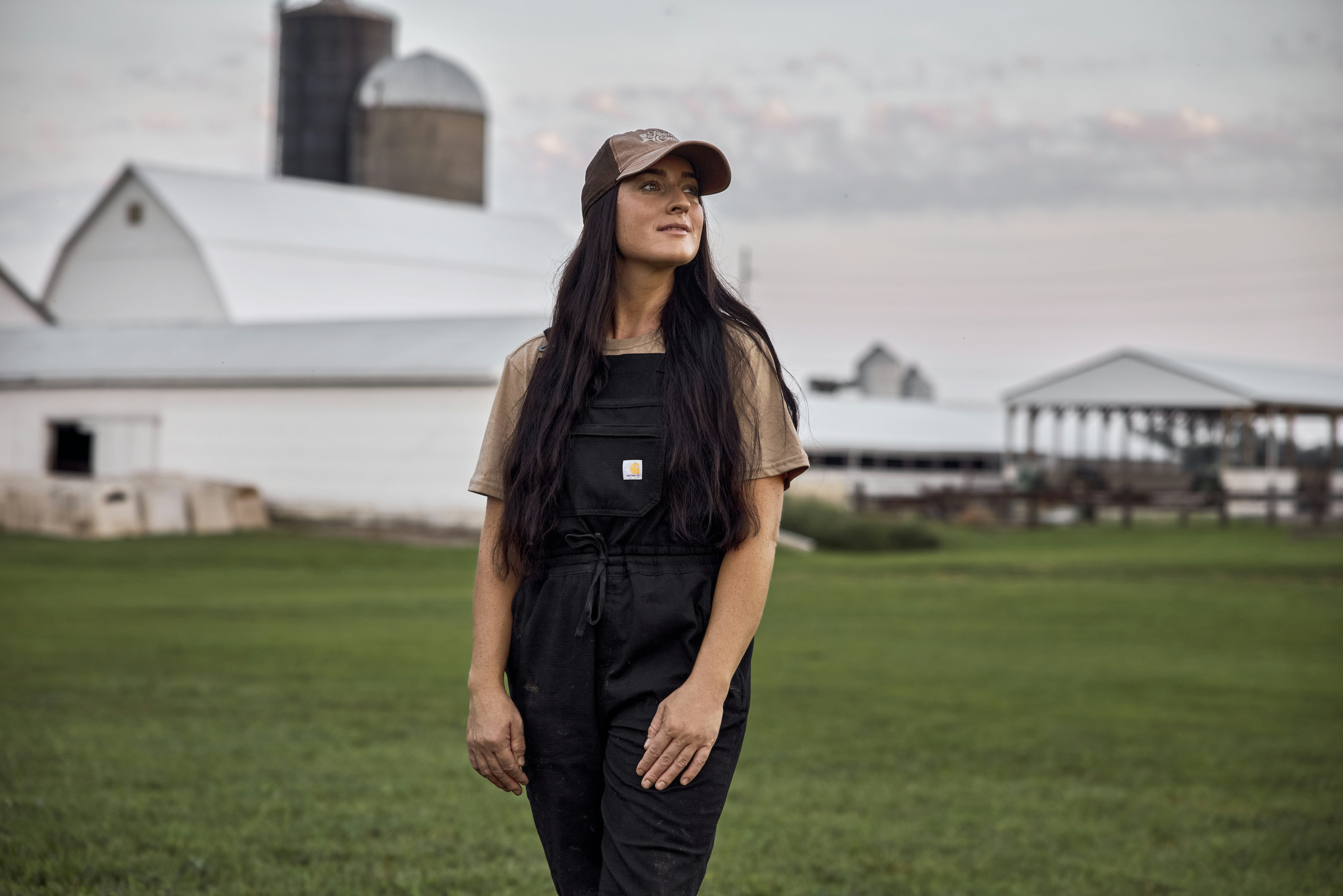 Woman standing outside a dairy barn. Ohio, USA.