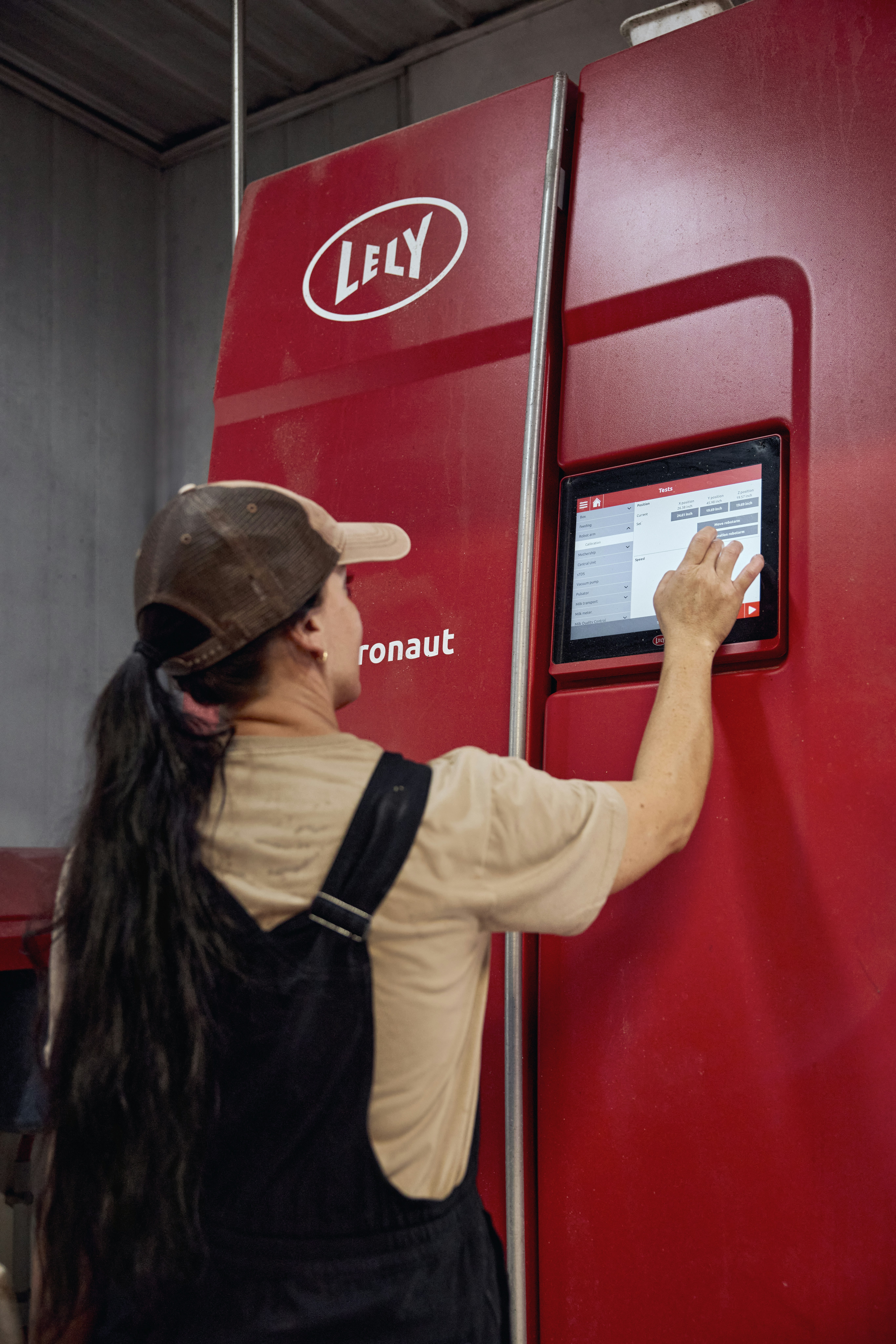 Woman using a robotic milking touchscreen. Ohio, USA.