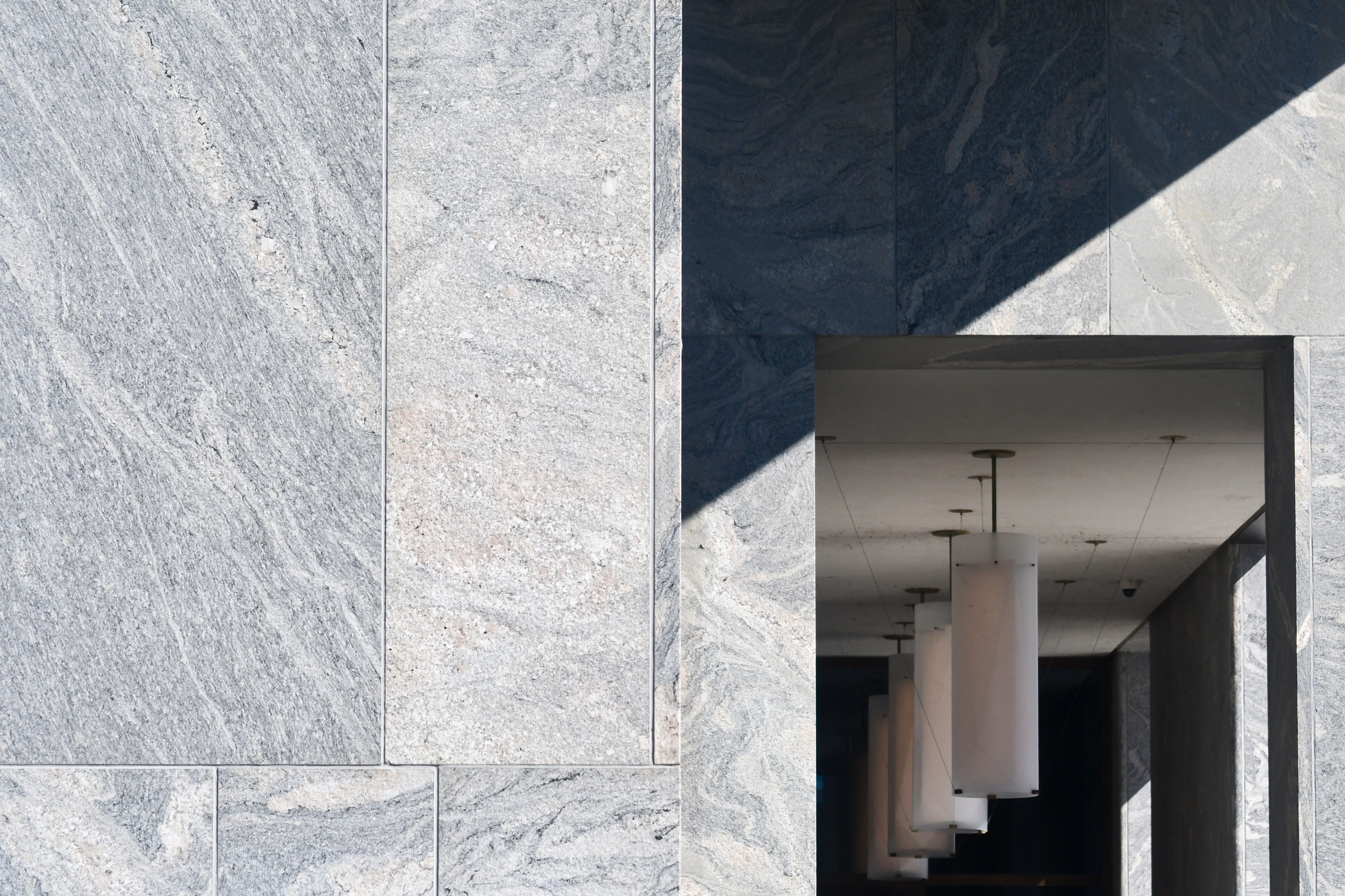A wall clad in large grey-and-white natural stone slabs