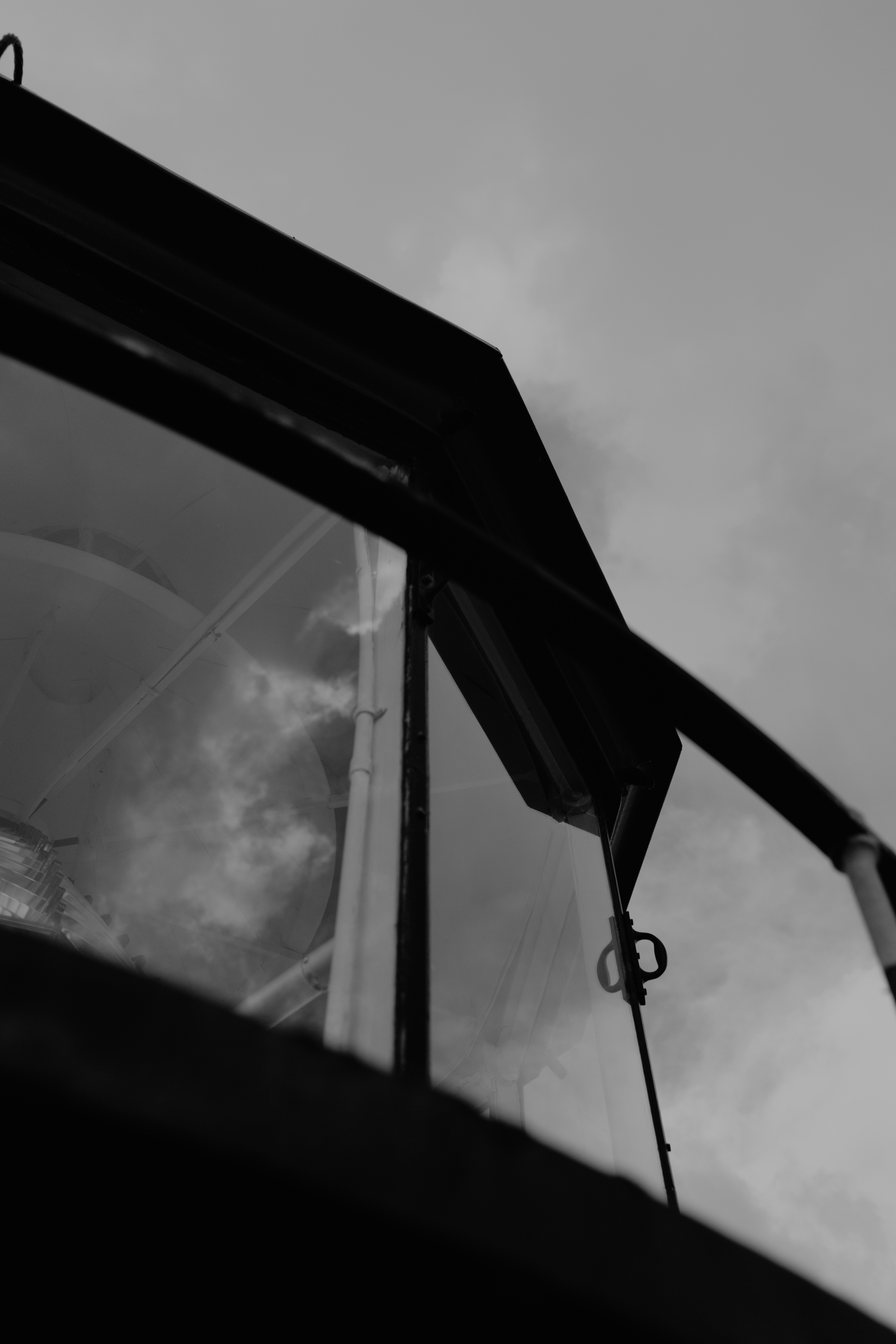 A black and white view of a lighthouse lantern room with glass panes
