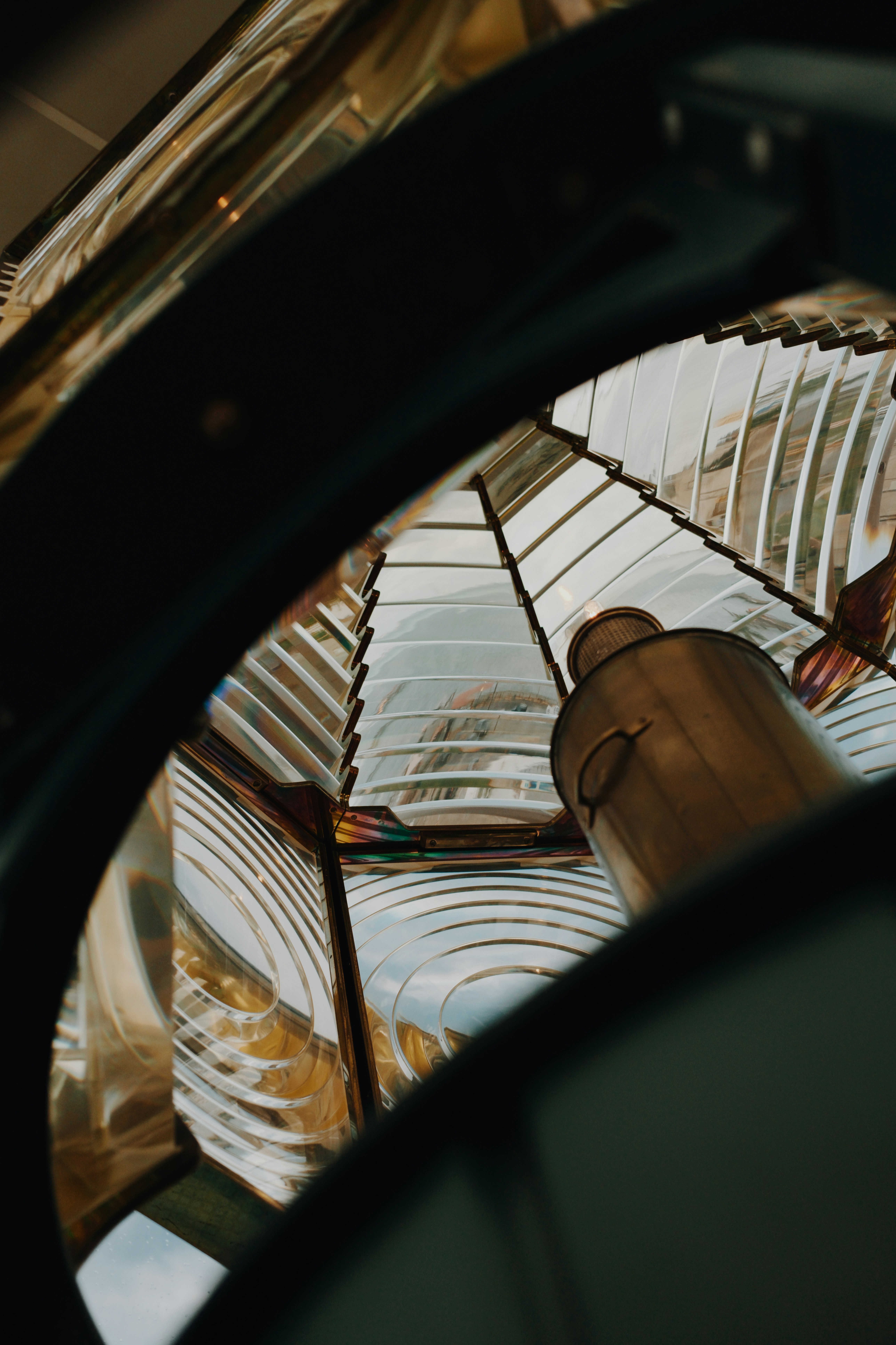 A Fresnel lens with concentric glass rings and a central metal lamp housing