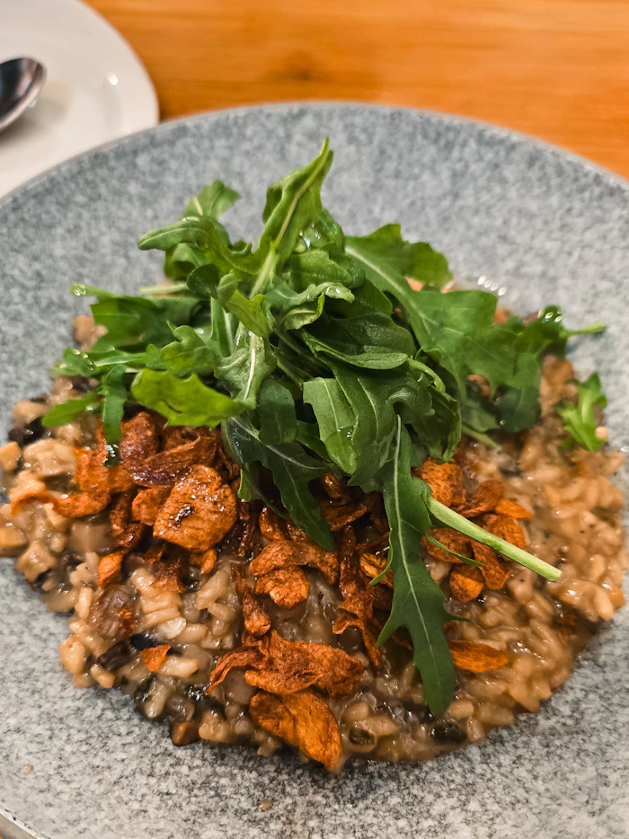 mushroom risotto topped with rocket and crispy garlic