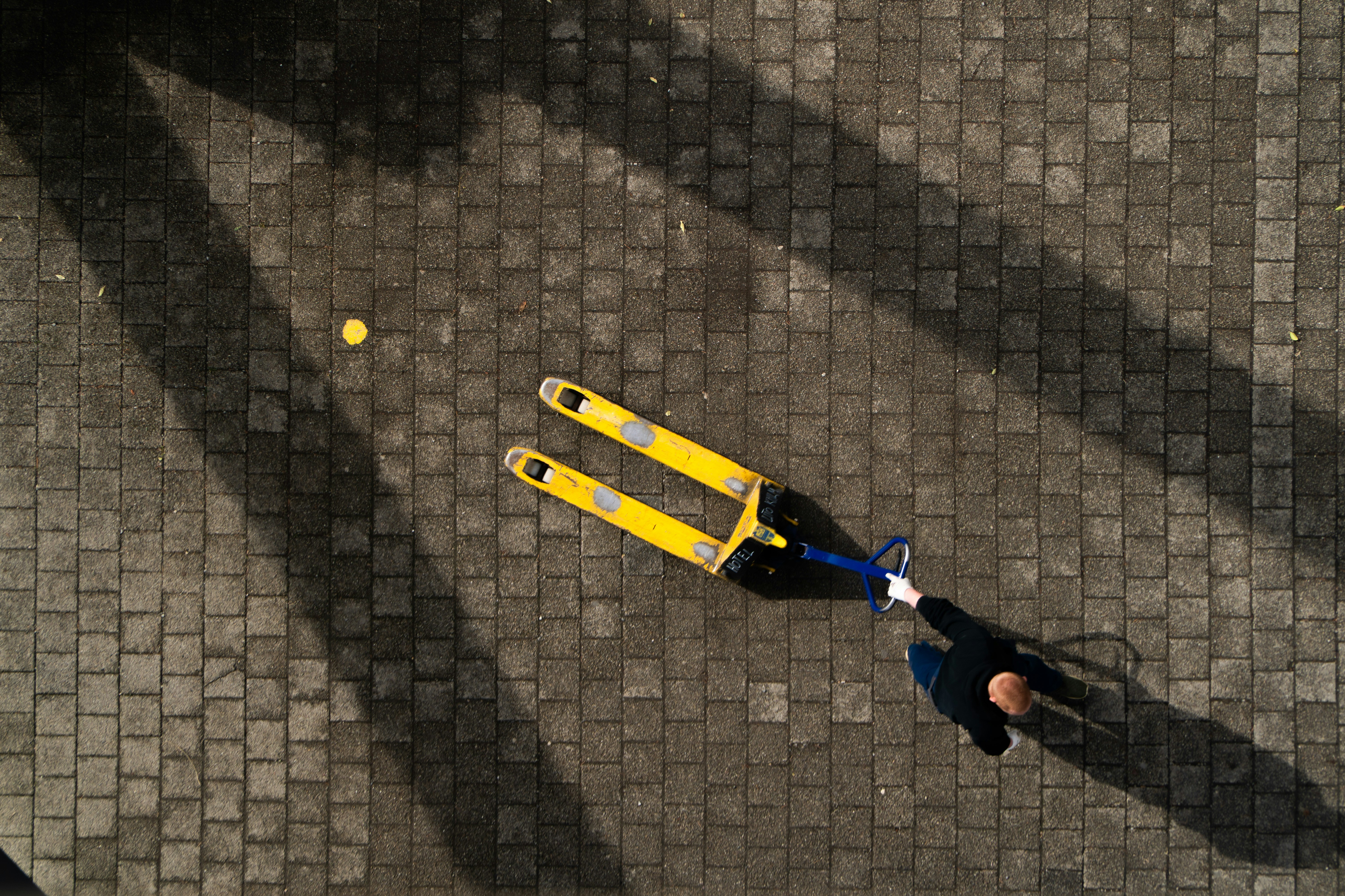 Persona tirando del transpalet amarillo - Foto gratuita en Unsplash