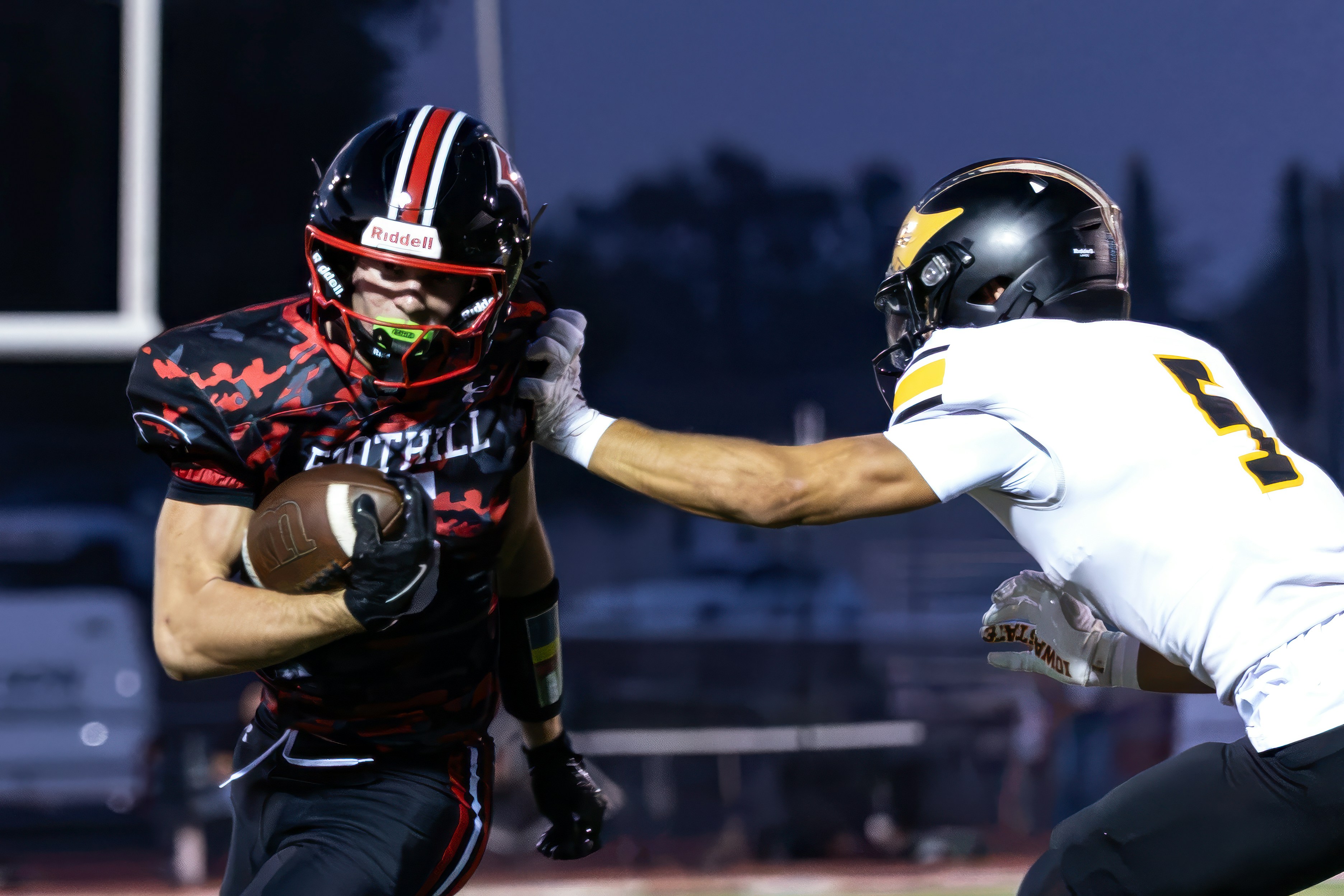 A football player in a black and red uniform running with the ball