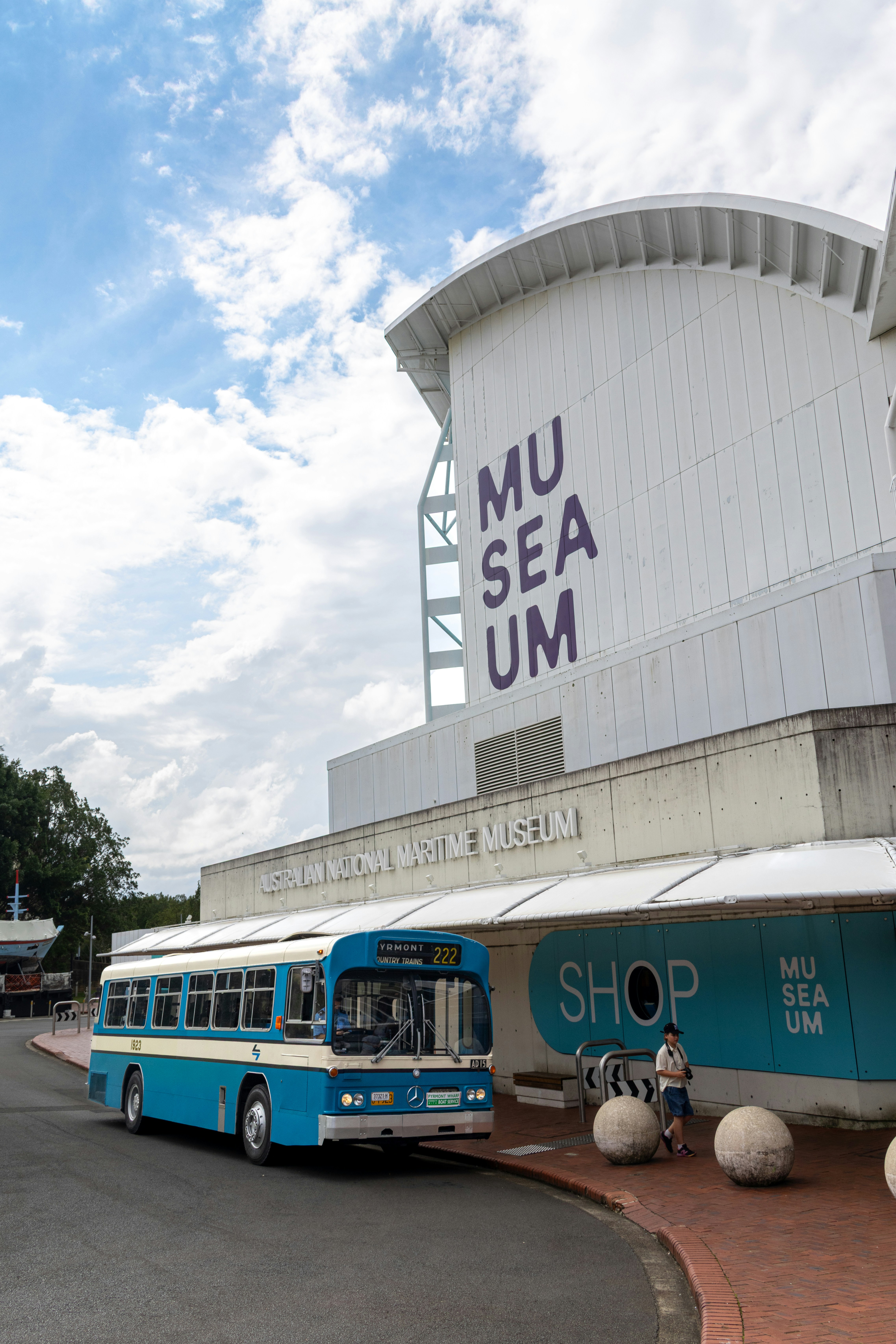 A blue and white bus parked outside the Australian National Maritime Museum in Sydney