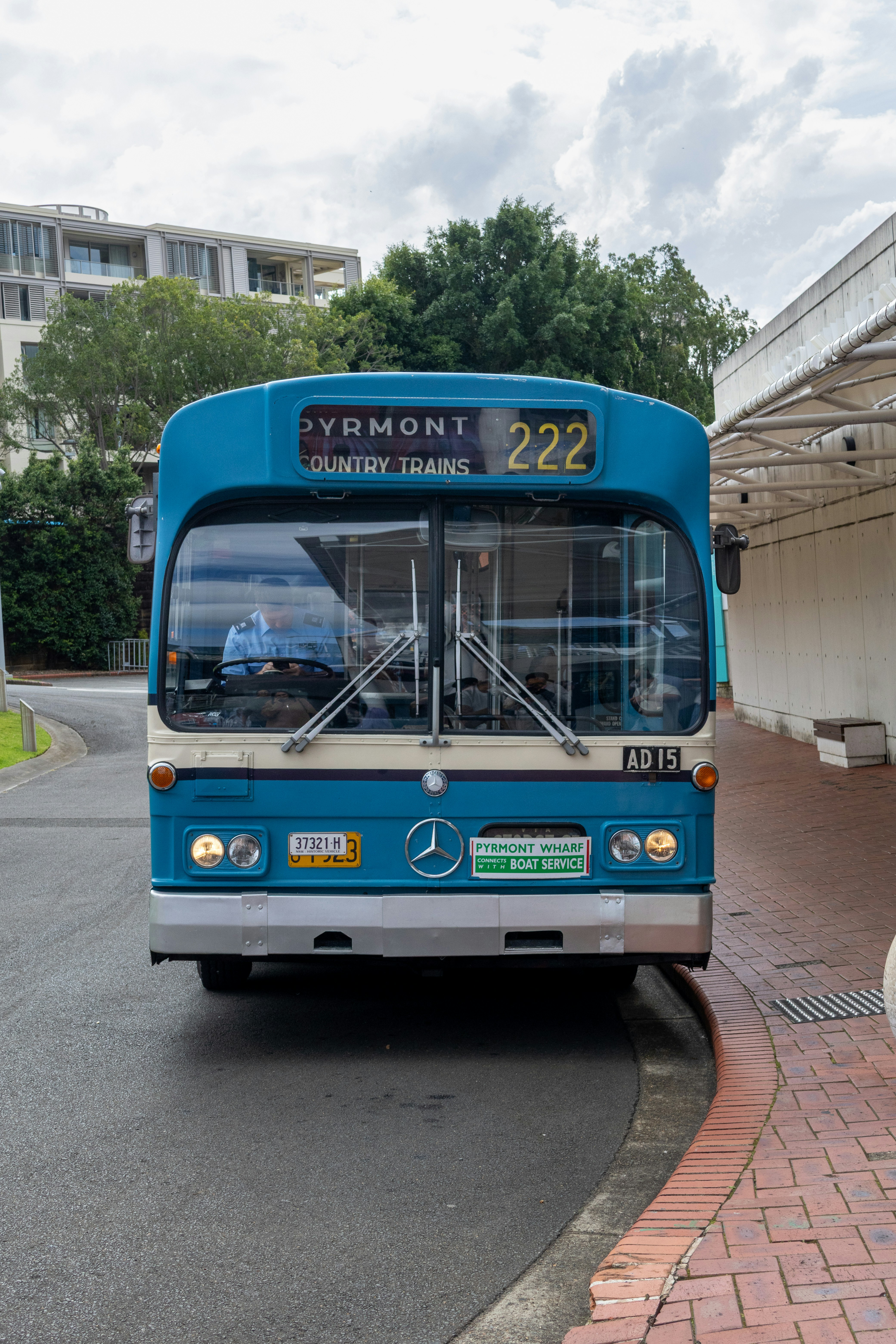 A blue bus with a Pyrmont sign at a paved terminal
