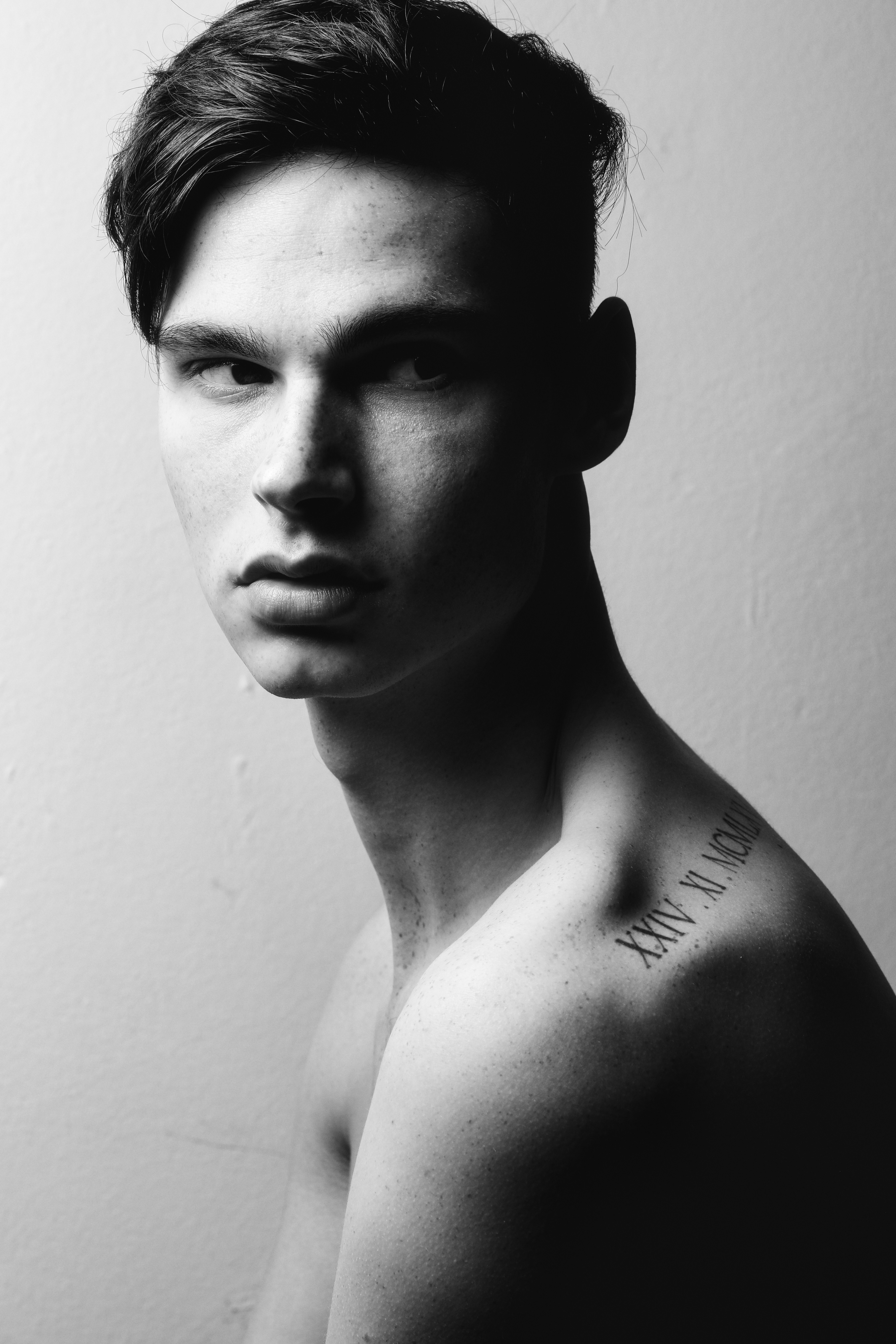 A young man with a roman numeral tattoo on his shoulder
