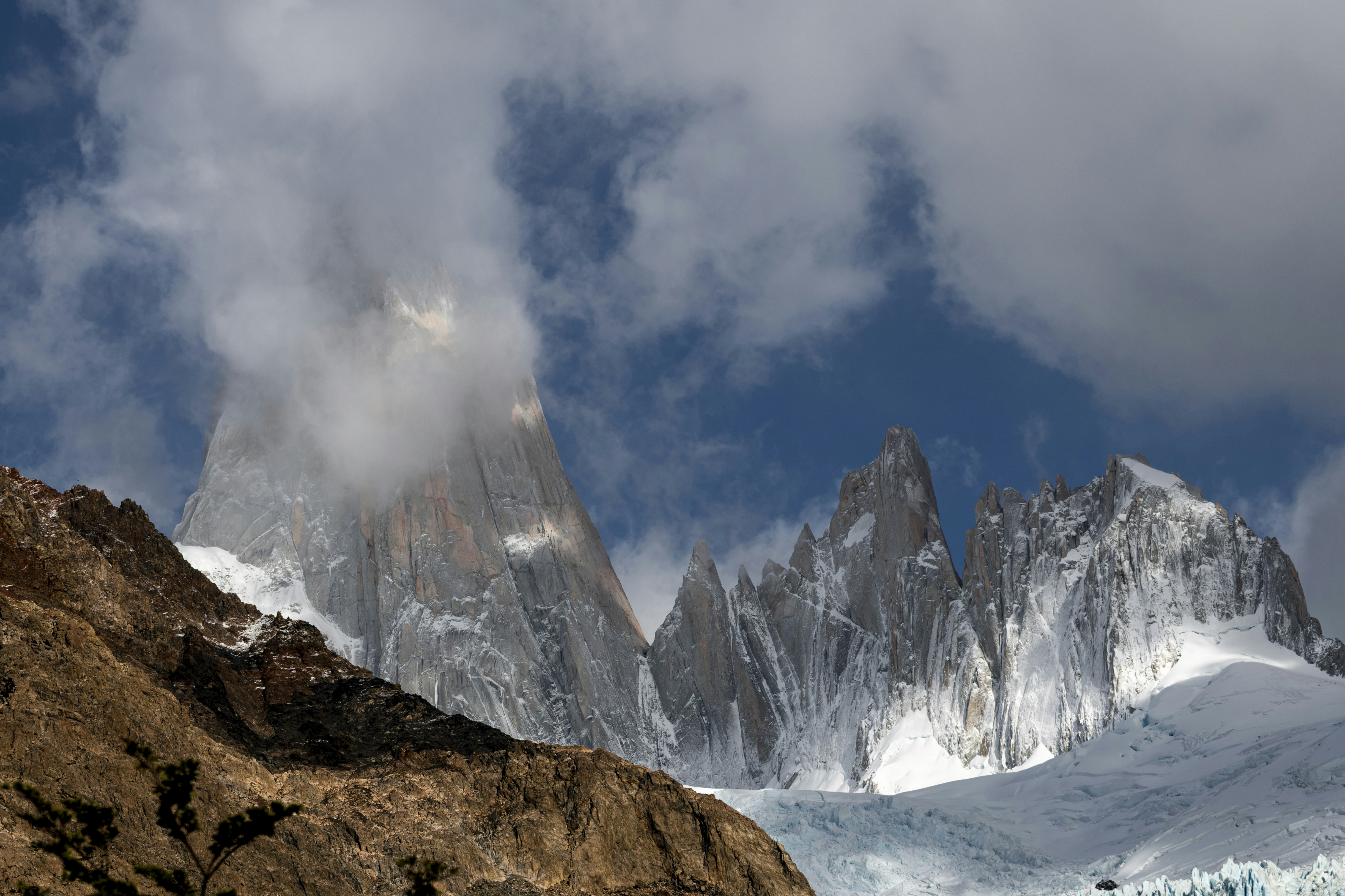 Snowy granite peaks of Mount Fitz Roy partially obscured by clouds in Patagonia