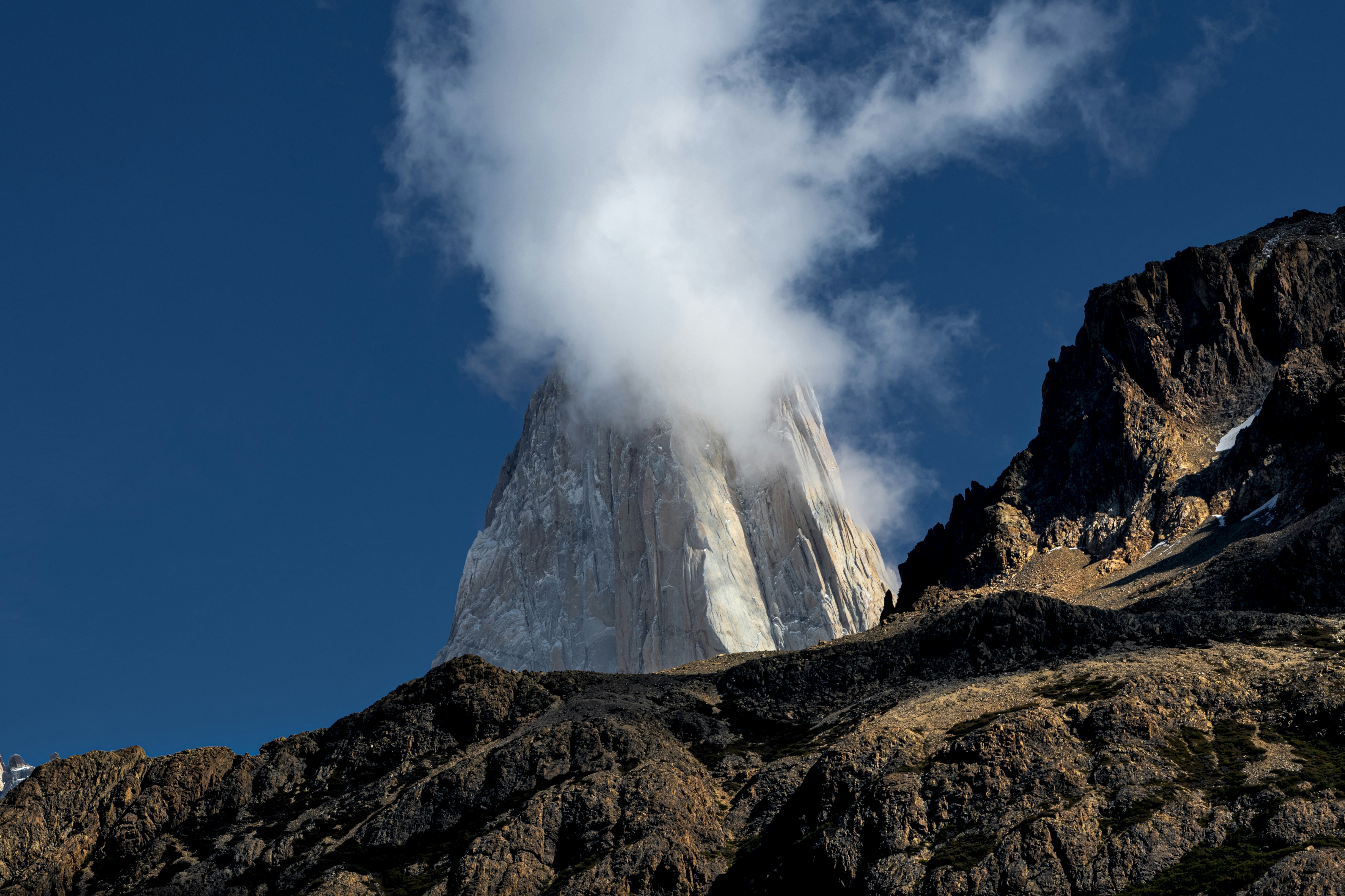 A cloud clinging to the peak of a jagged granite mountain