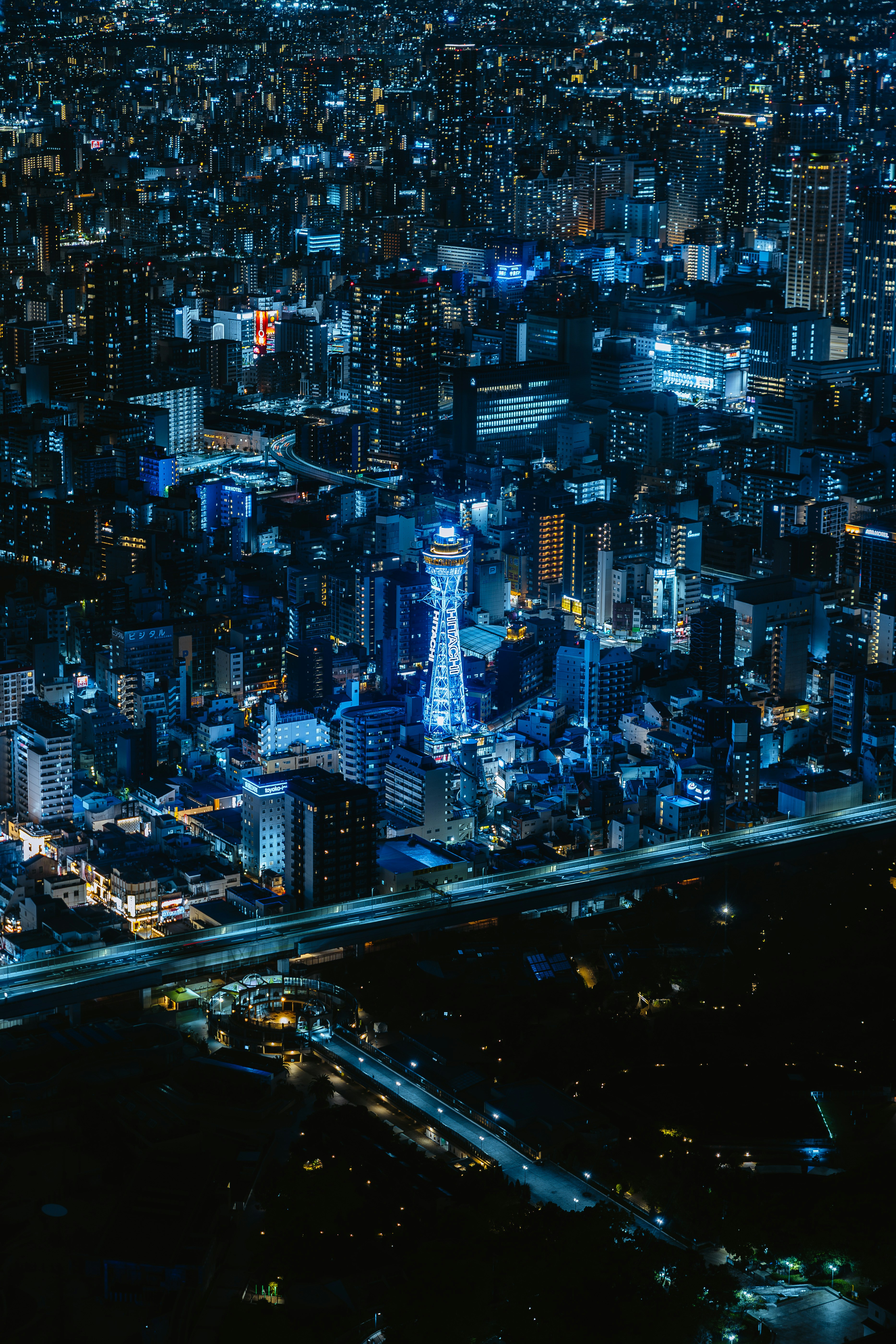 An aerial view of the illuminated Tsutenkaku Tower in Osaka at night