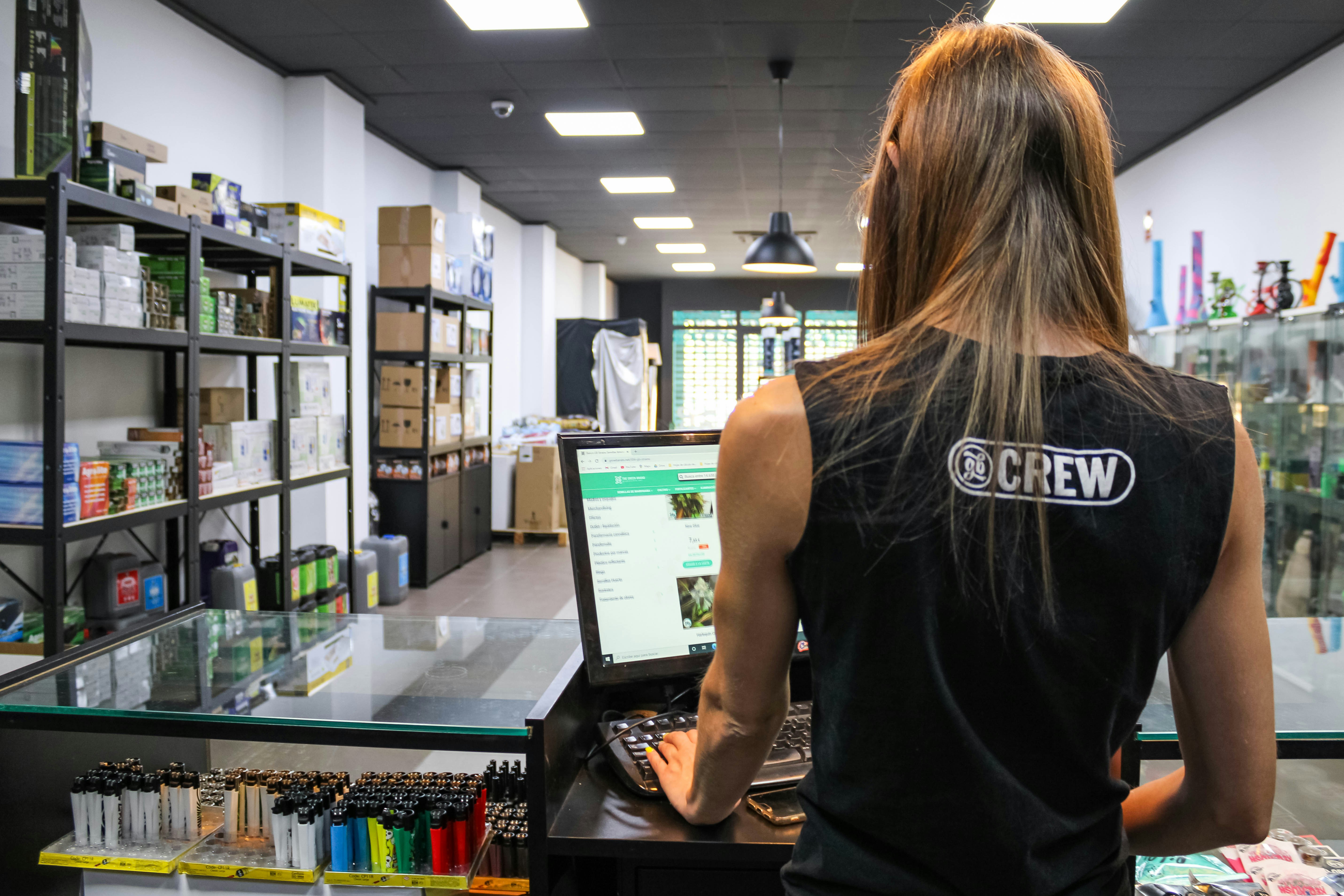 Une personne en débardeur noir utilisant un ordinateur au comptoir