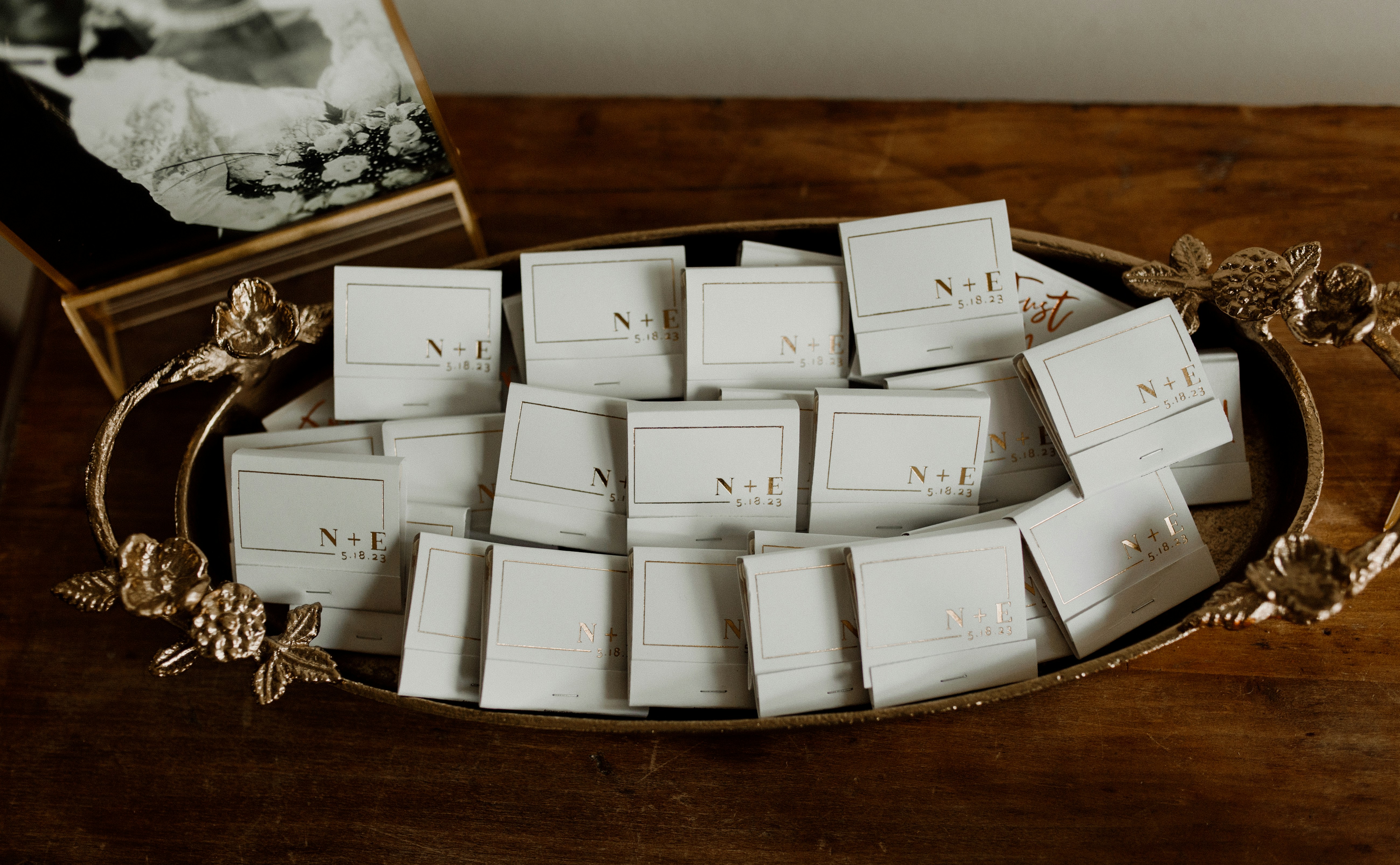 Un tas de boîtes d’allumettes blanches avec des lettres en feuille d’or dans un plateau décoratif en or