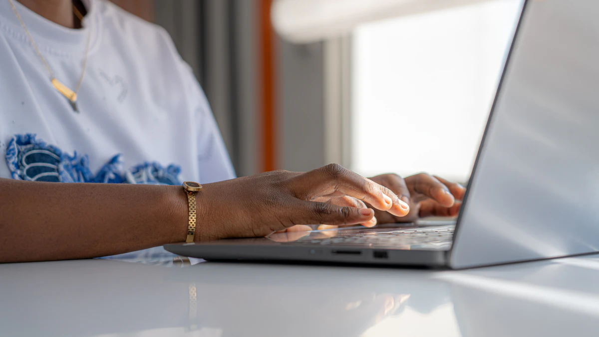 Orang mengetik di laptop di meja putih yang terang
