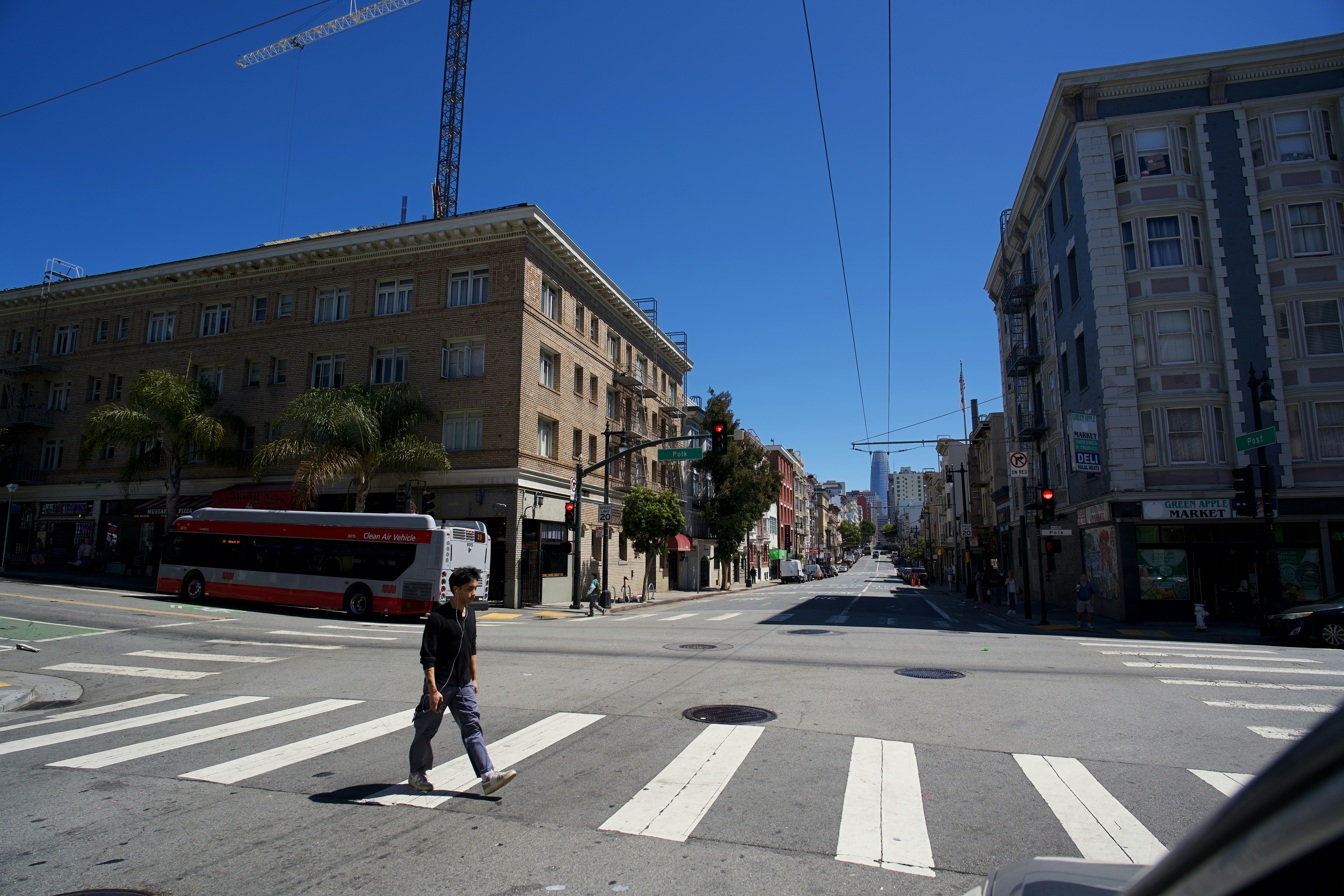 Una persona che attraversa un attraversamento pedonale a un incrocio cittadino di San Francisco