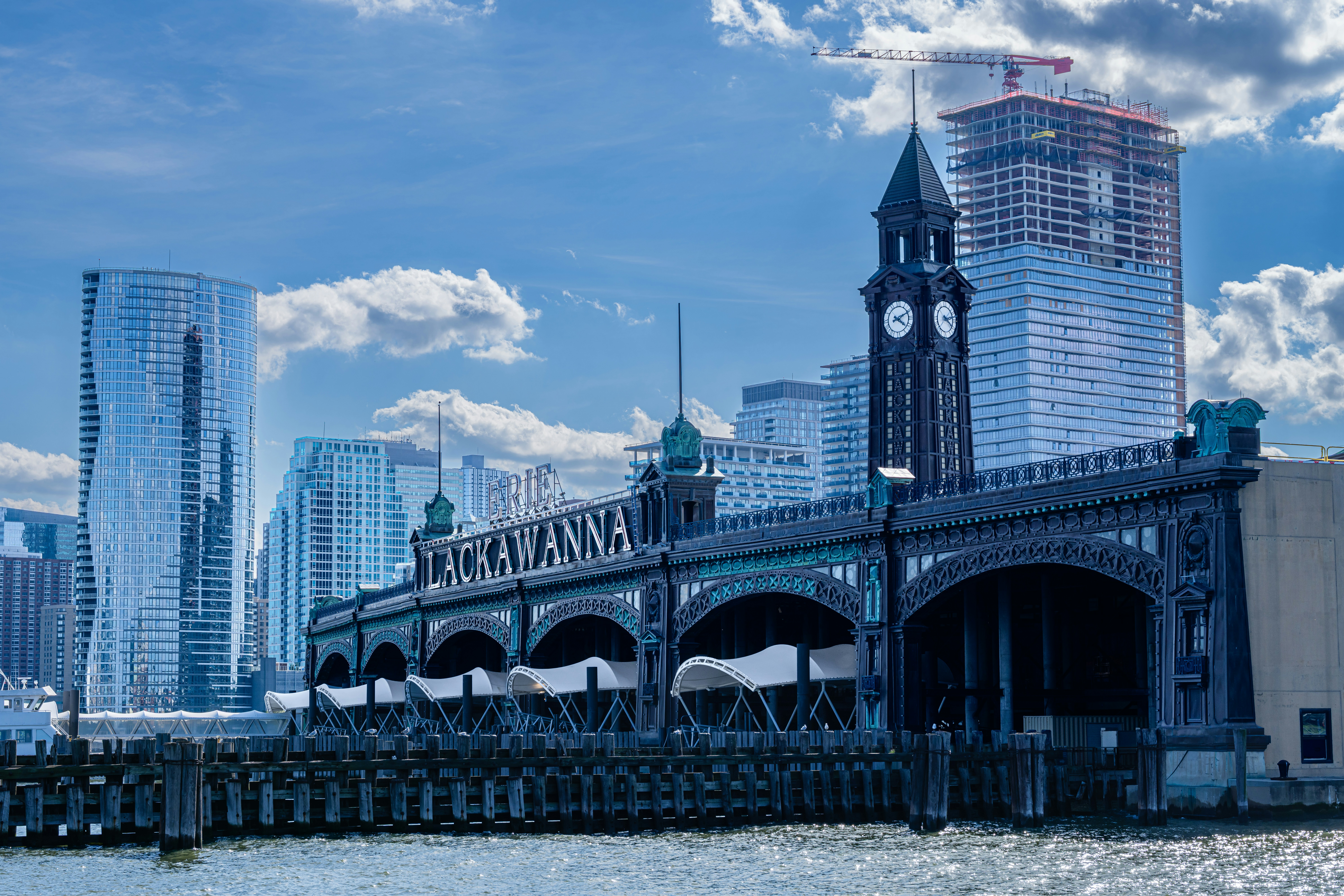 Historic Lackawanna Terminal and clock tower on the Hoboken waterfront, with modern high-rise construction rising behind