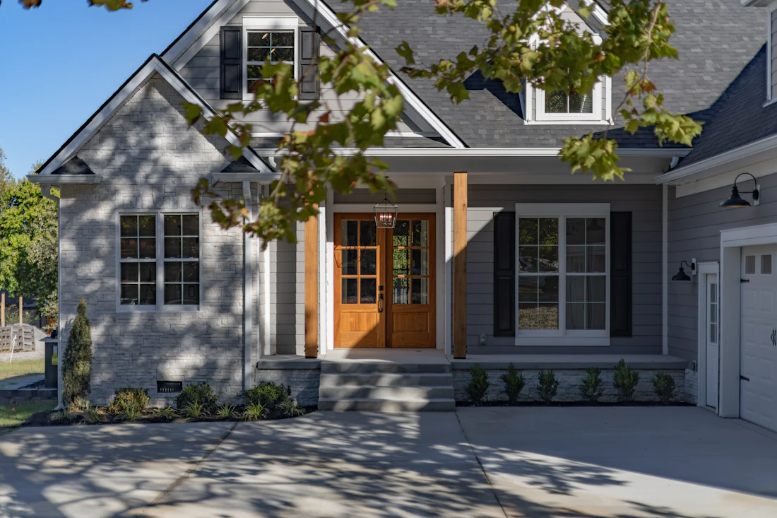 Suburban house with a stone facade and grey siding