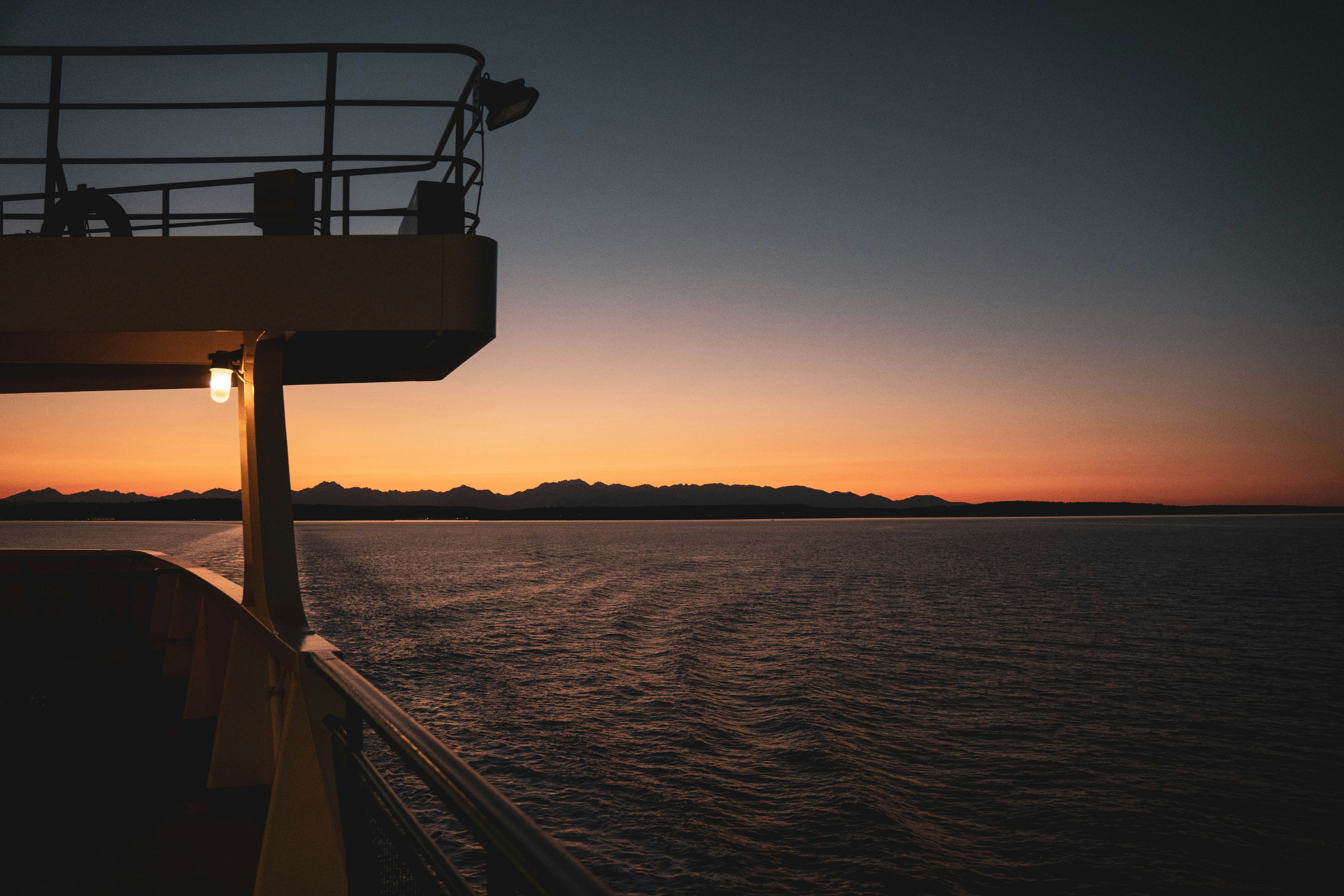 Ferry deck overlooking mountains at dusk - Free Photo on Unsplash