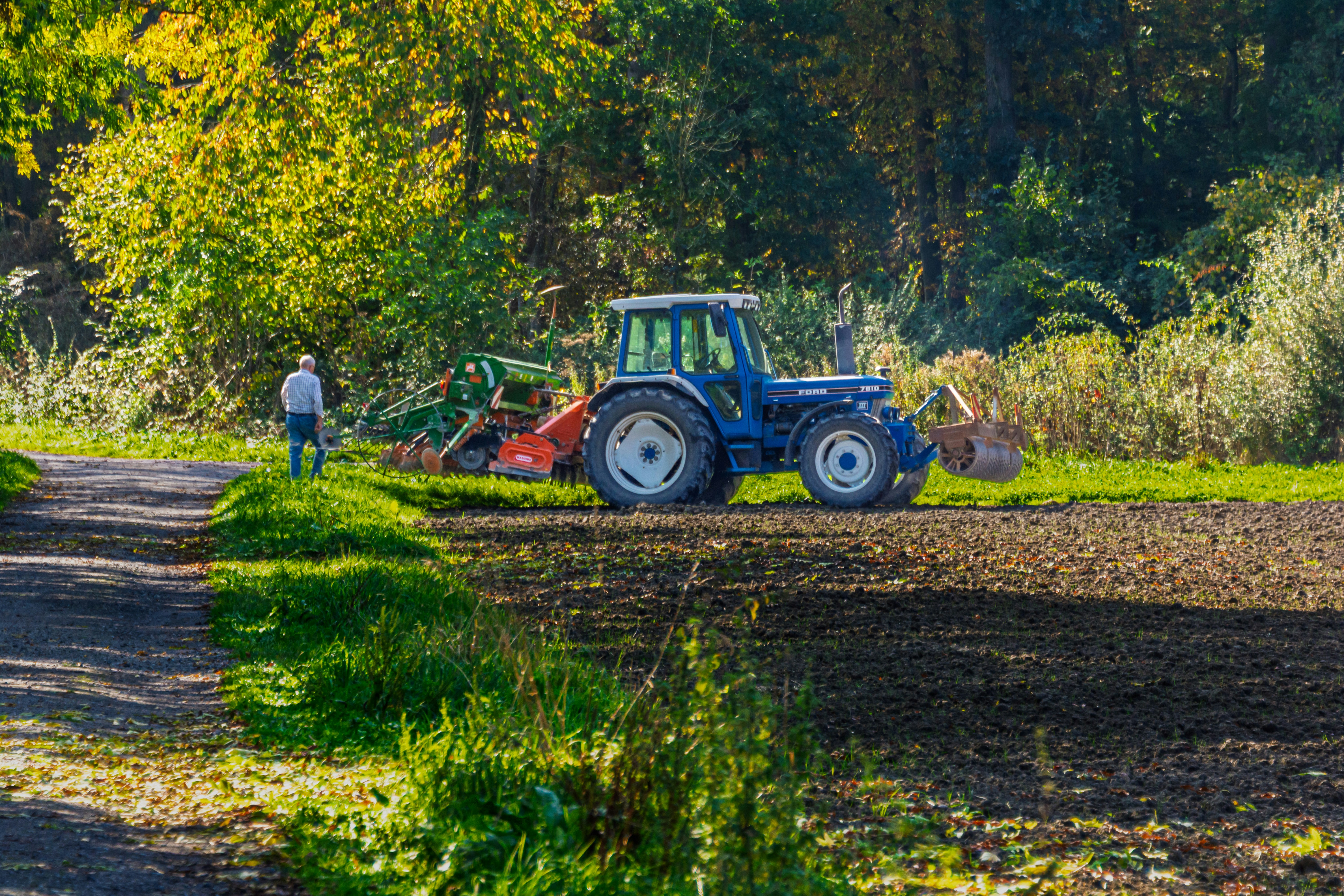 Blue tractor in sunlit field - Free Photo on Unsplash