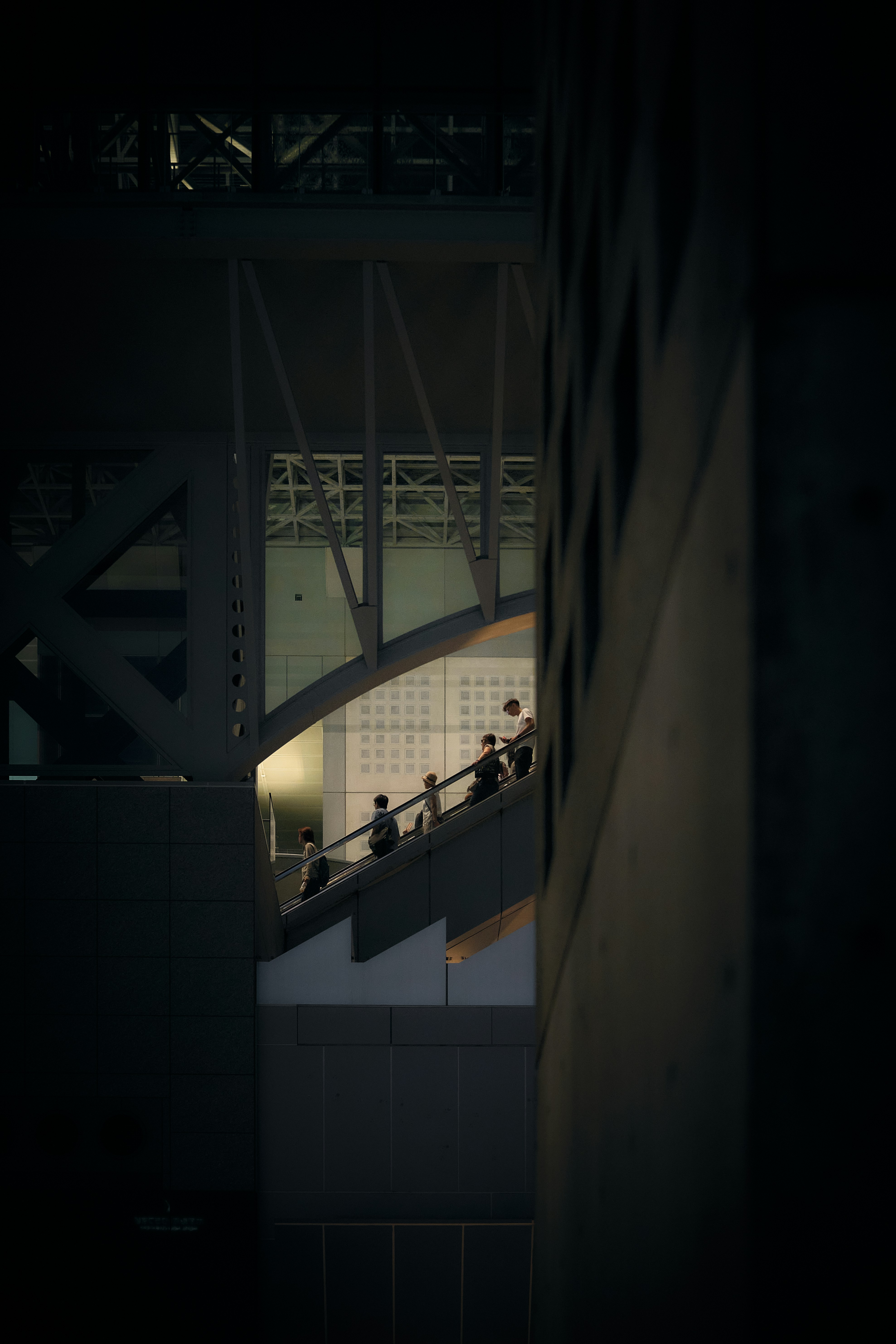 Des personnes montant sur un escalatoron dans l’intérieur architecturalement moderne de la gare de Kyoto au Japon