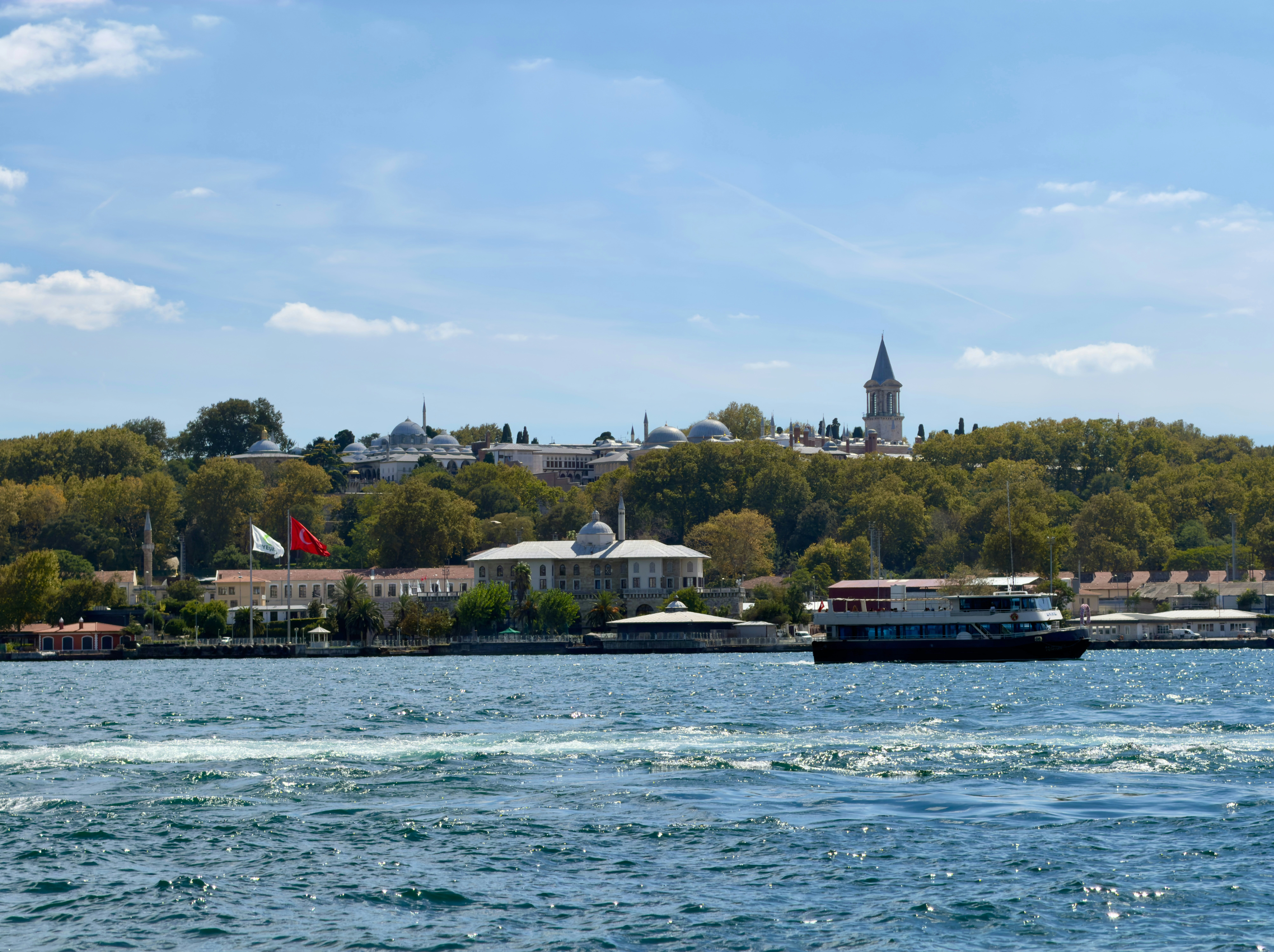 A passenger boat on the Bosphorus with the Topkapi Palace in Istanbul in the background