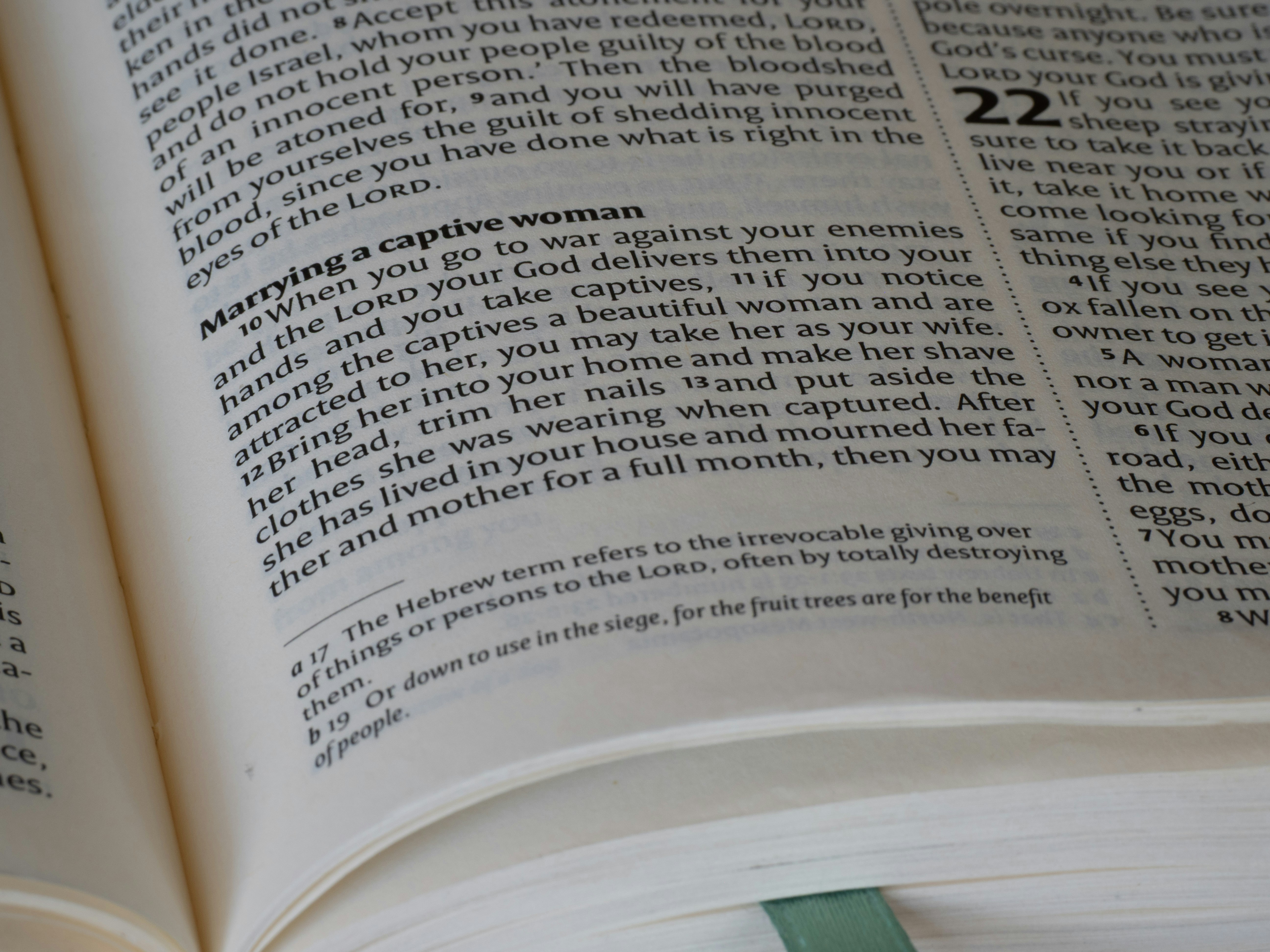 A close-up of an open book with printed text on thin paper pages