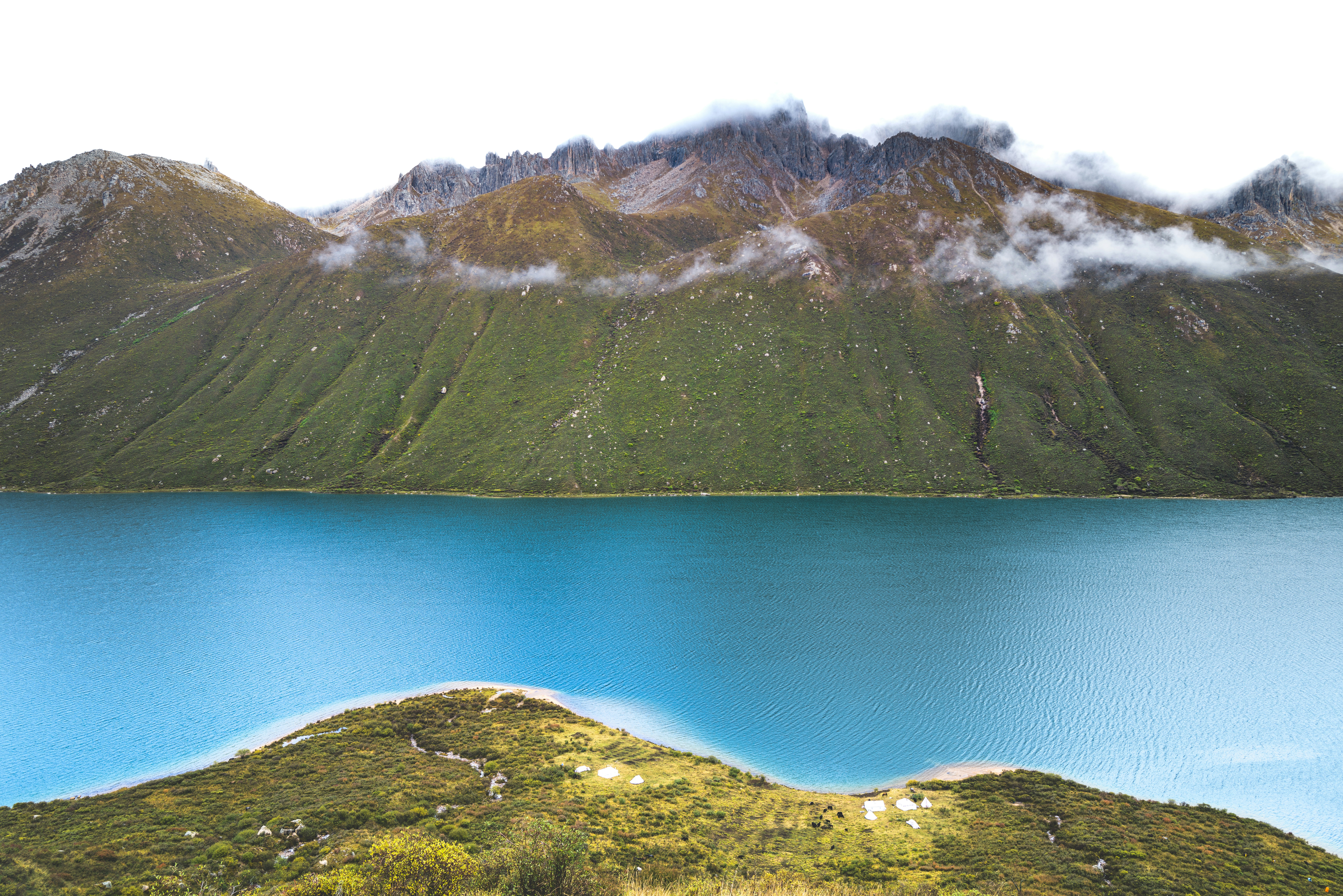 Turquoise lake below green mountain range - Free Photo on Unsplash