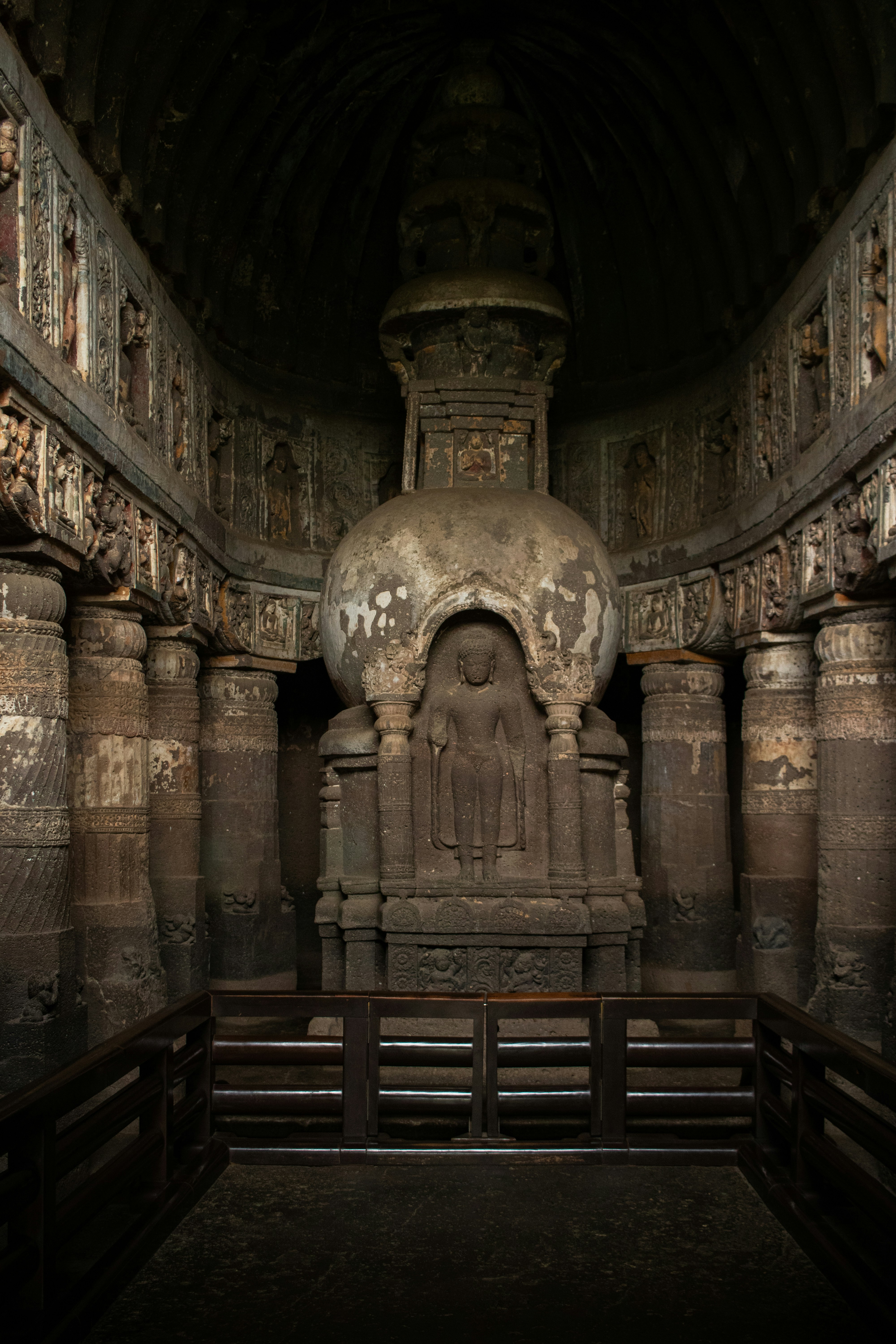 The ornate stone stupa with a carved Buddha figure inside Cave 19 at the Ajanta Caves in India
