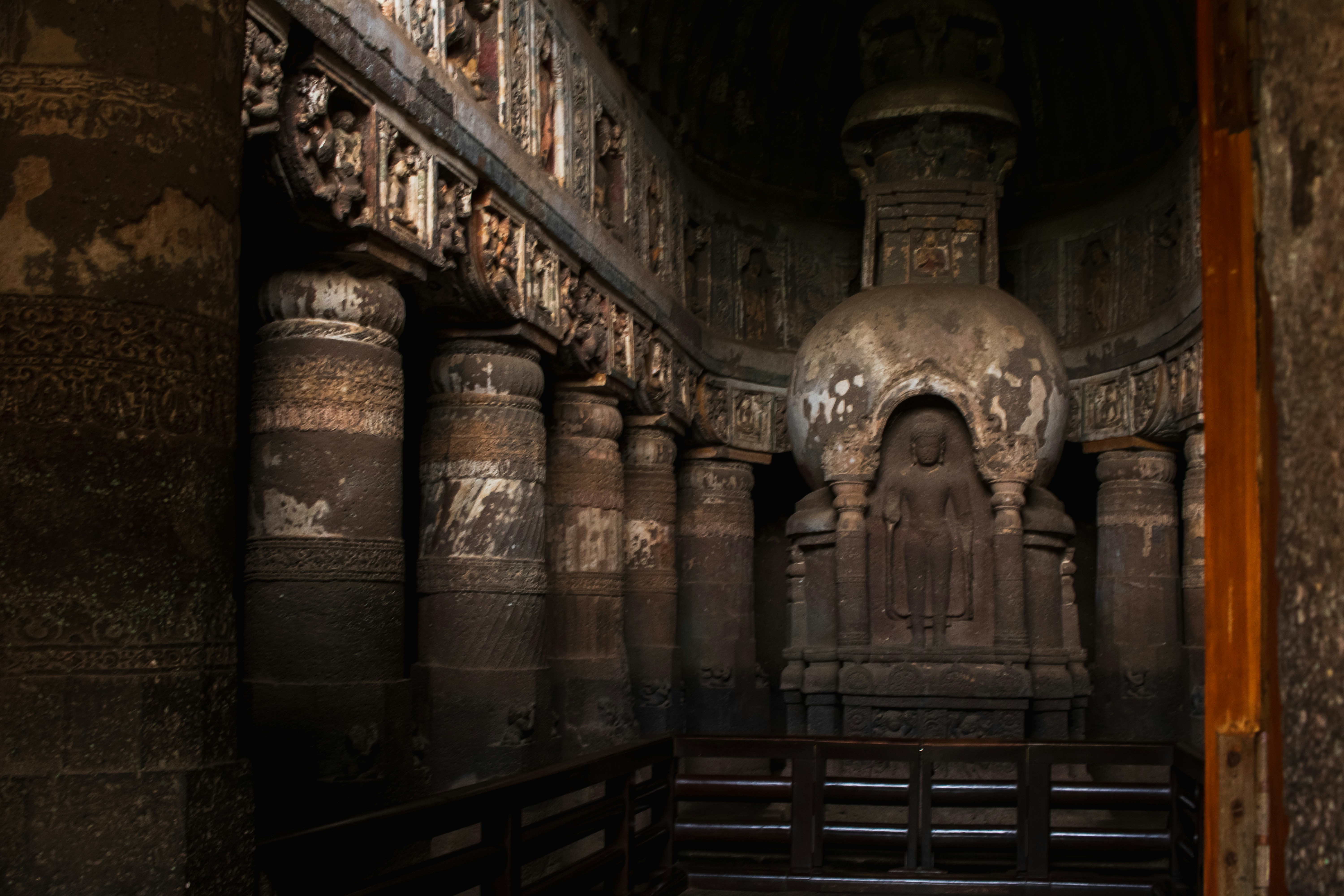 Ornate stone columns and a central stupa inside the Ajanta Caves in Maharashtra, India