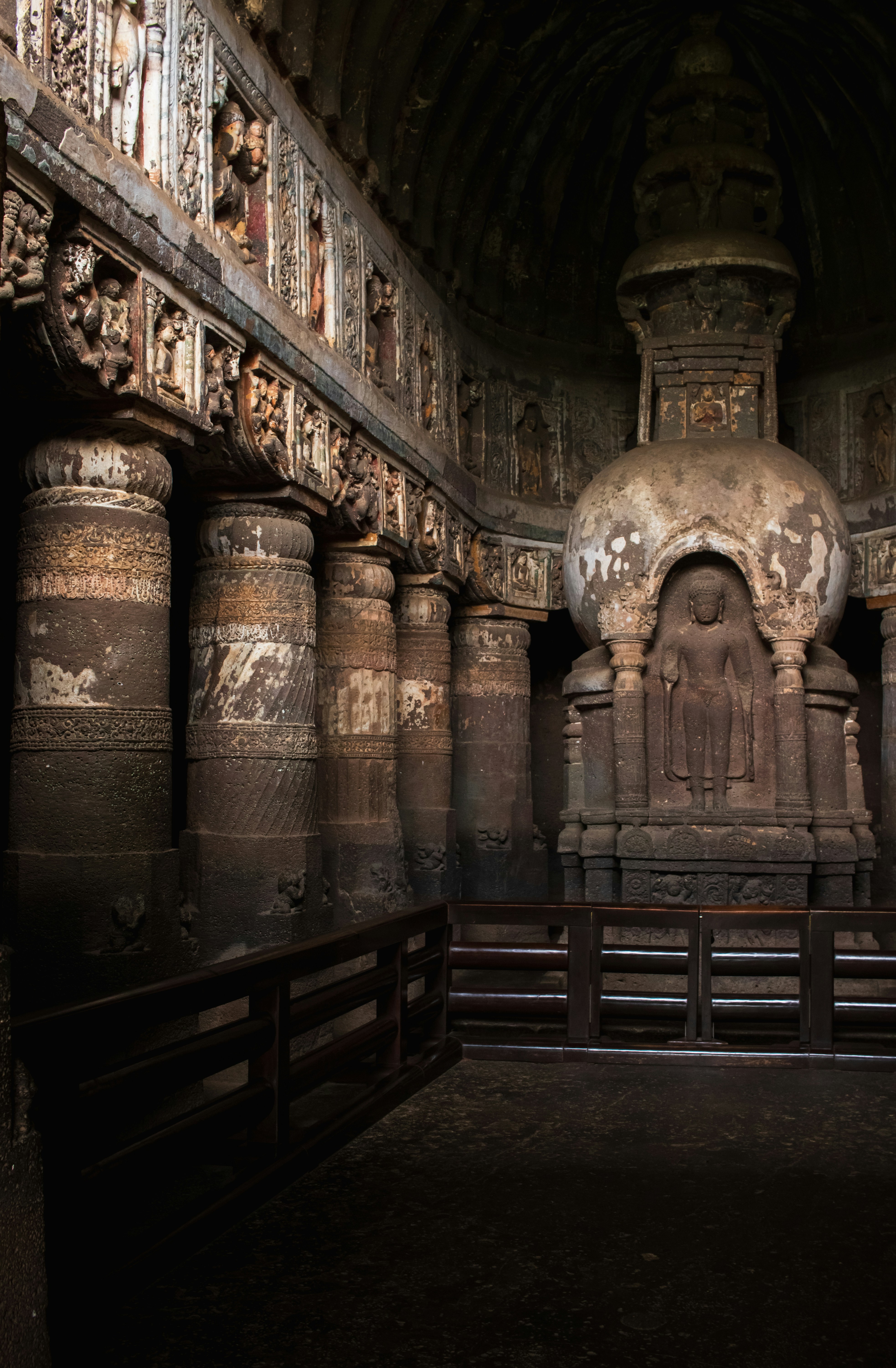 Ornate stone columns and a carved stupa inside Cave 19 at the Ajanta Caves in India