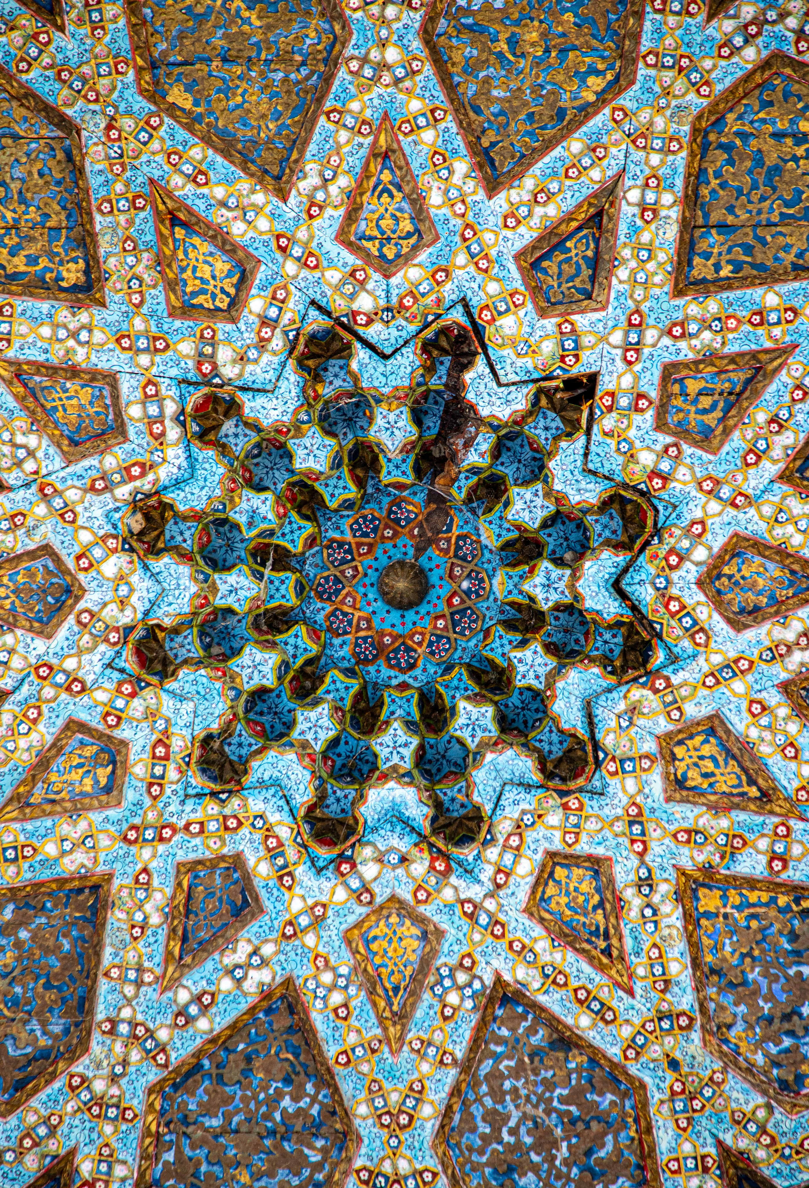 Intricate blue and gold geometric ceiling patterns with star motifs in a traditional architectural style