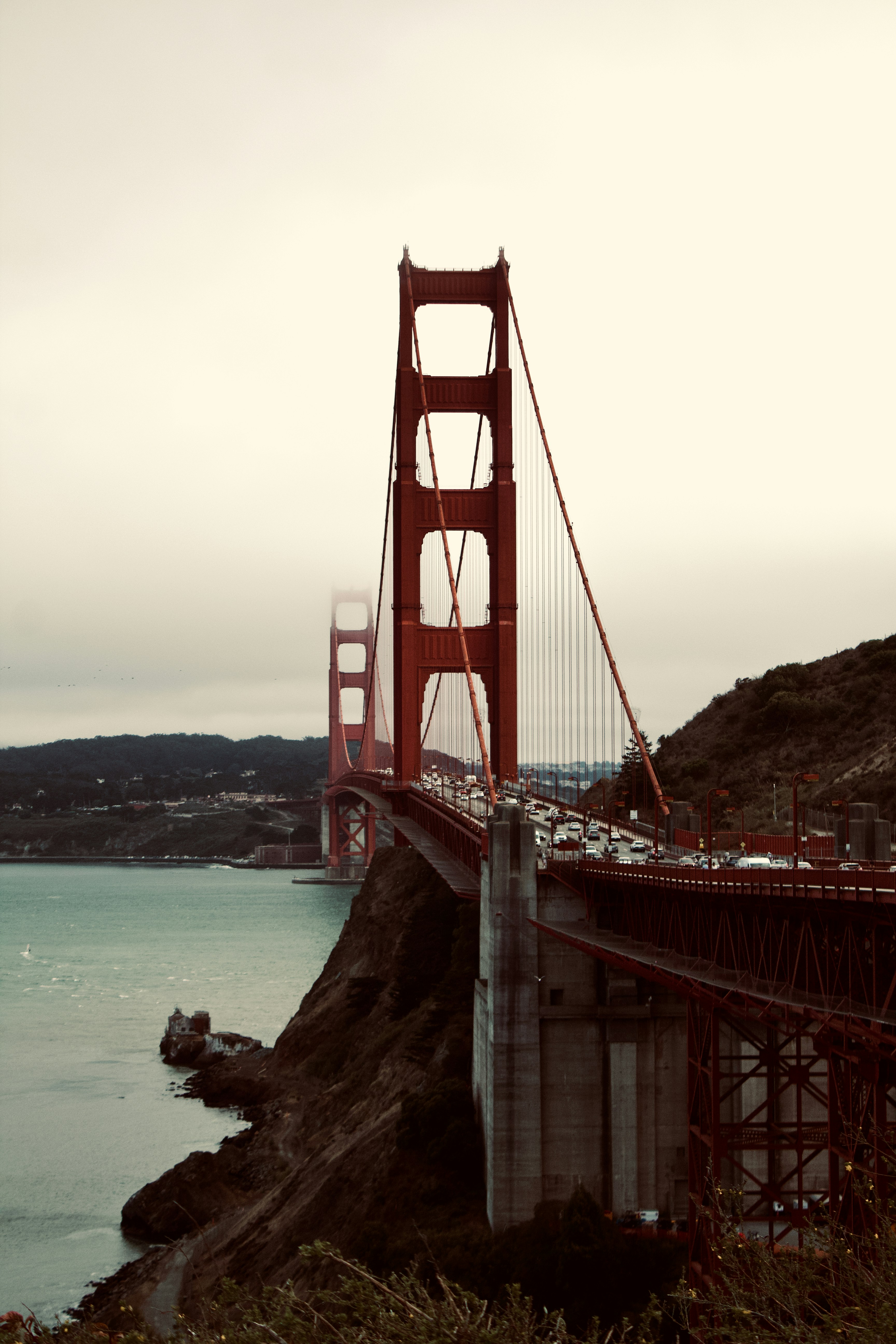 The Golden Gate Bridge in San Francisco with traffic crossing under a cloudy sky