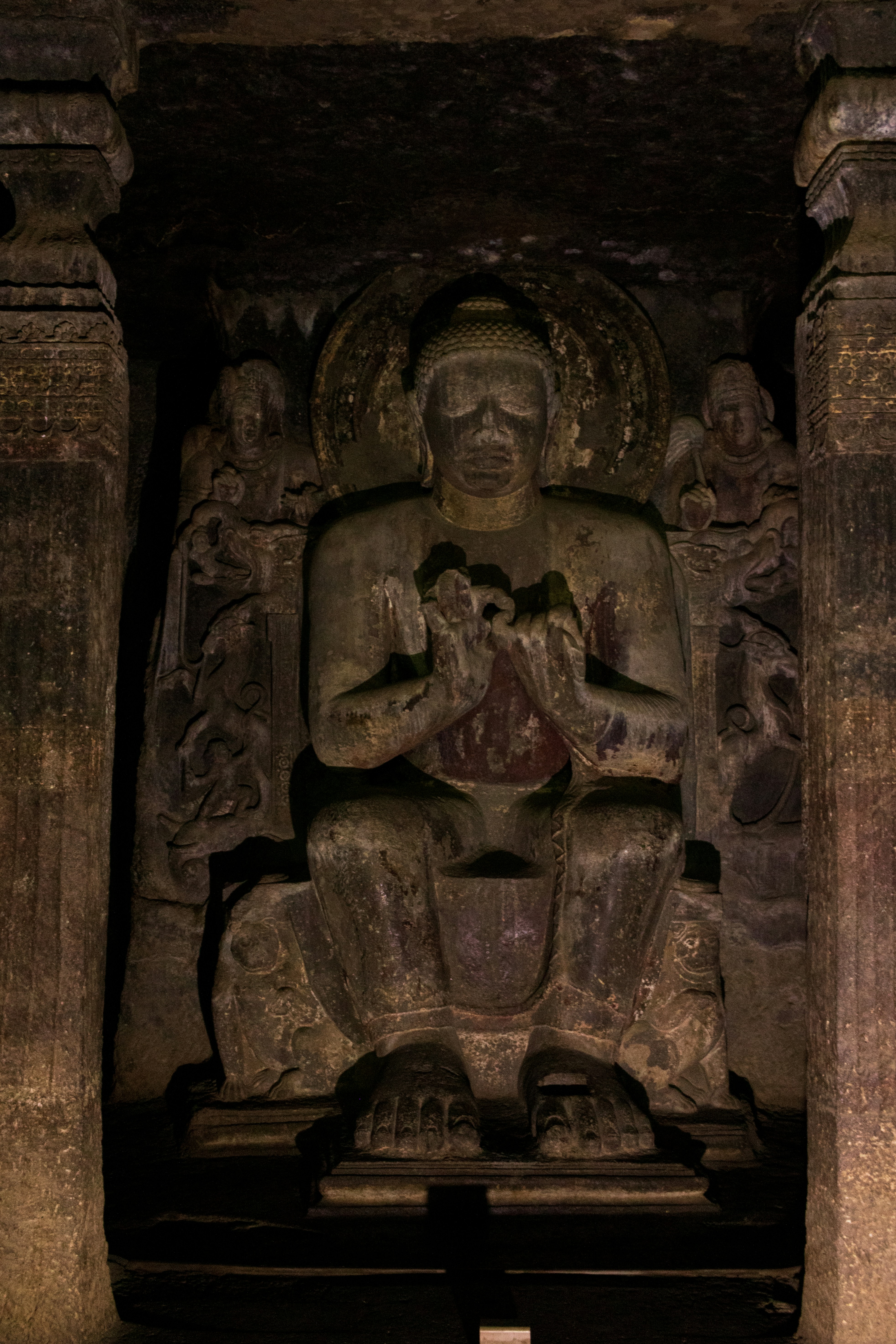 A seated Buddha statue carved into the rock wall of the Ajanta Caves in Maharashtra