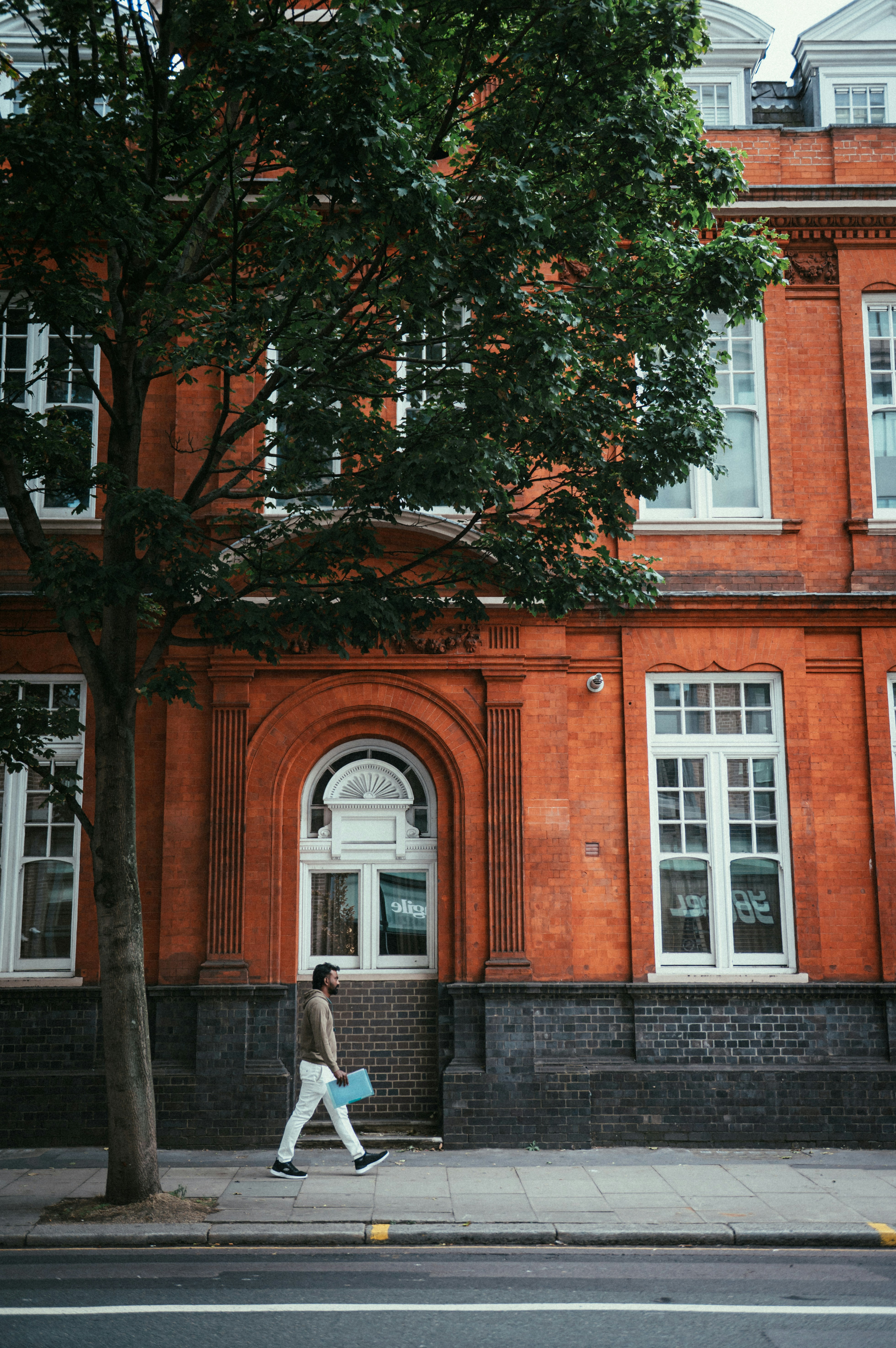Person walking past red brick building - Free Photo on Unsplash