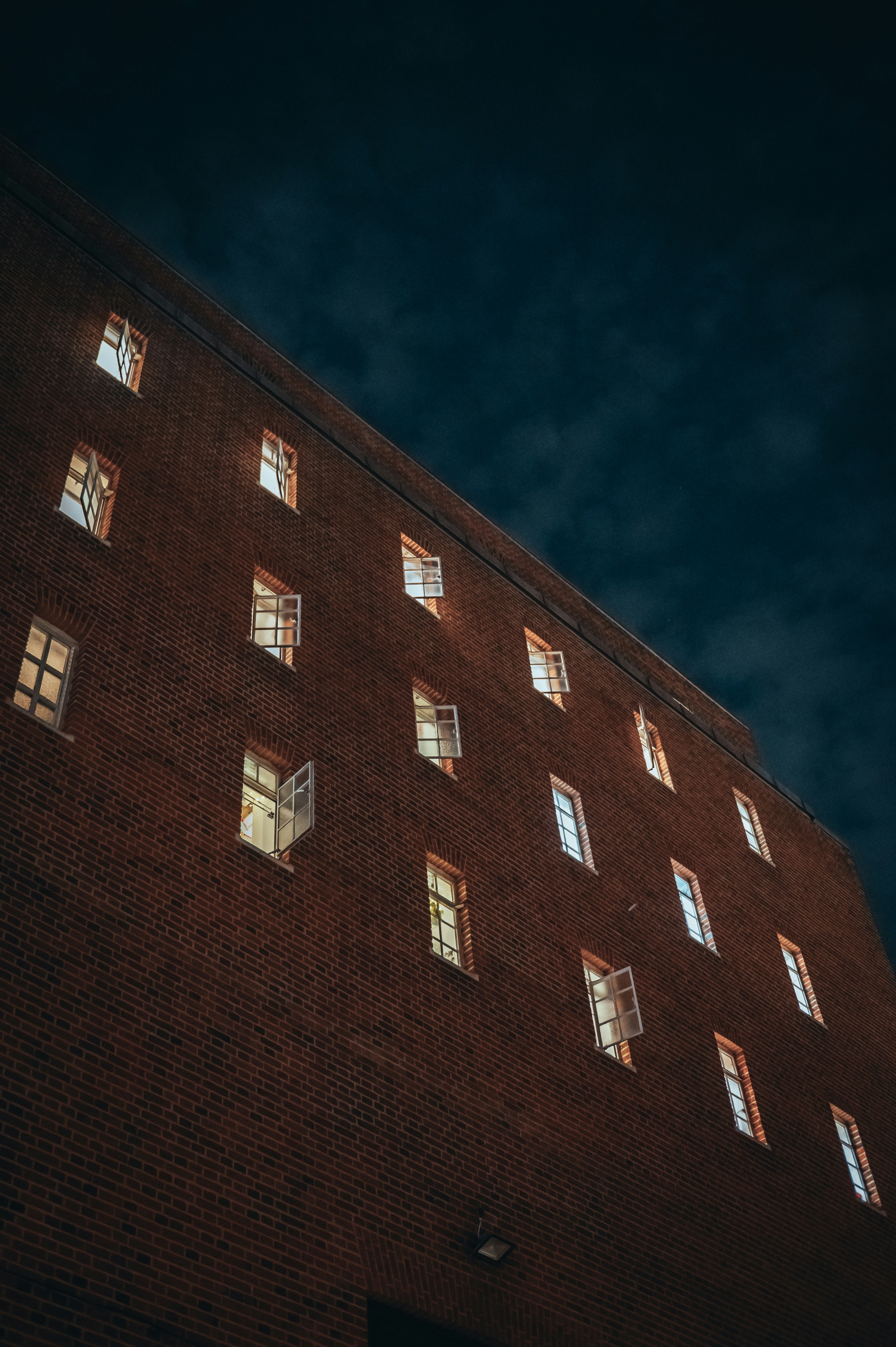 Brick building facade with glowing windows - Free Photo on Unsplash