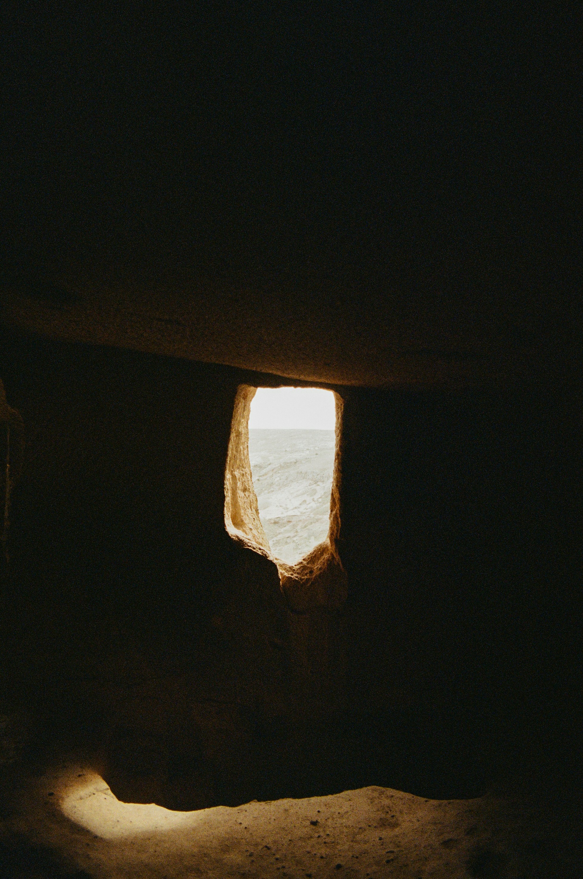A view of a bright landscape through a jagged opening in a dark stone wall - 相关推荐