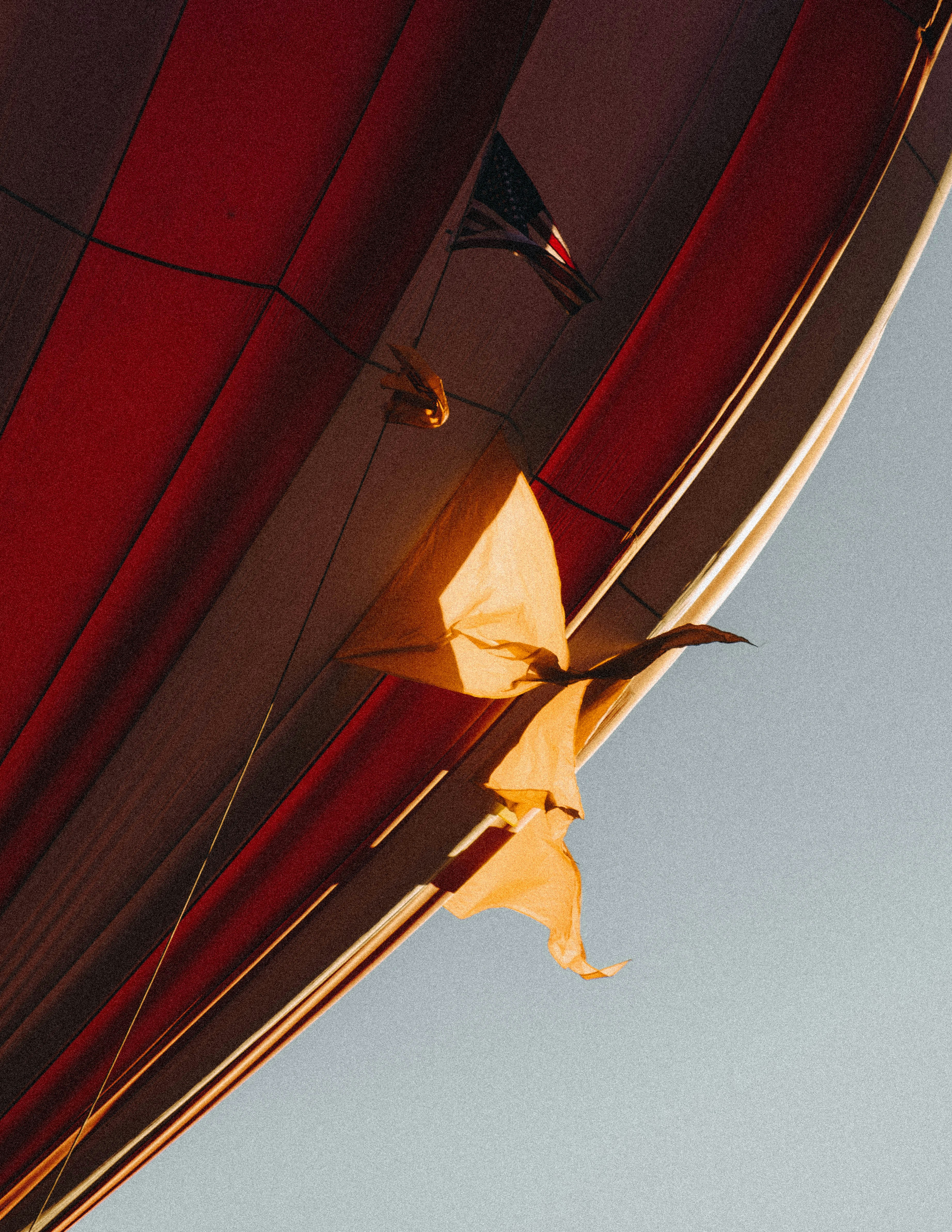 Un tessuto di mongolfiera a righe rosse e bianche con una piccola bandiera americana contro un cielo limpido