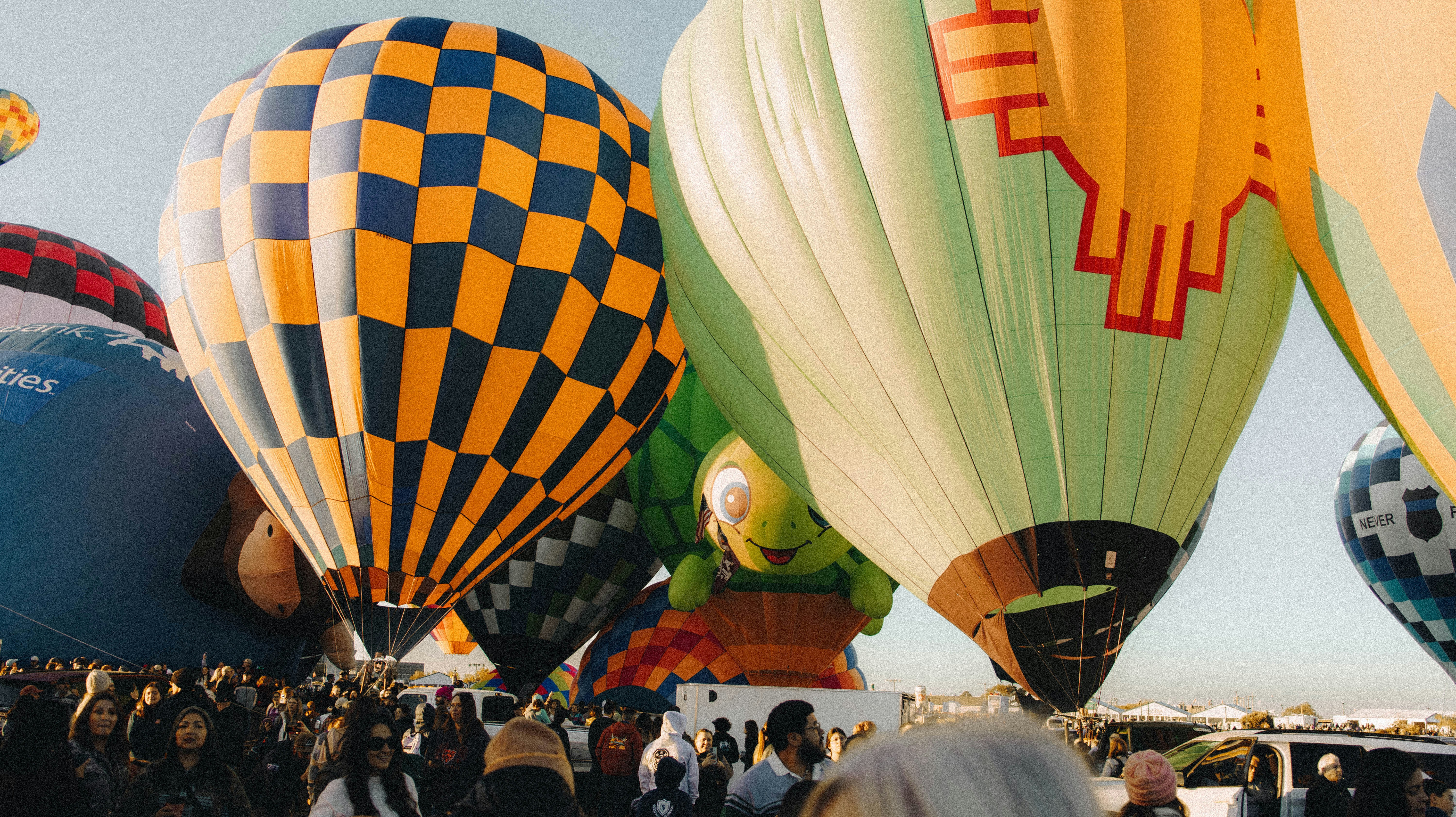 Mongolfiere colorate che si sollevano sopra una folla di persone durante un festival