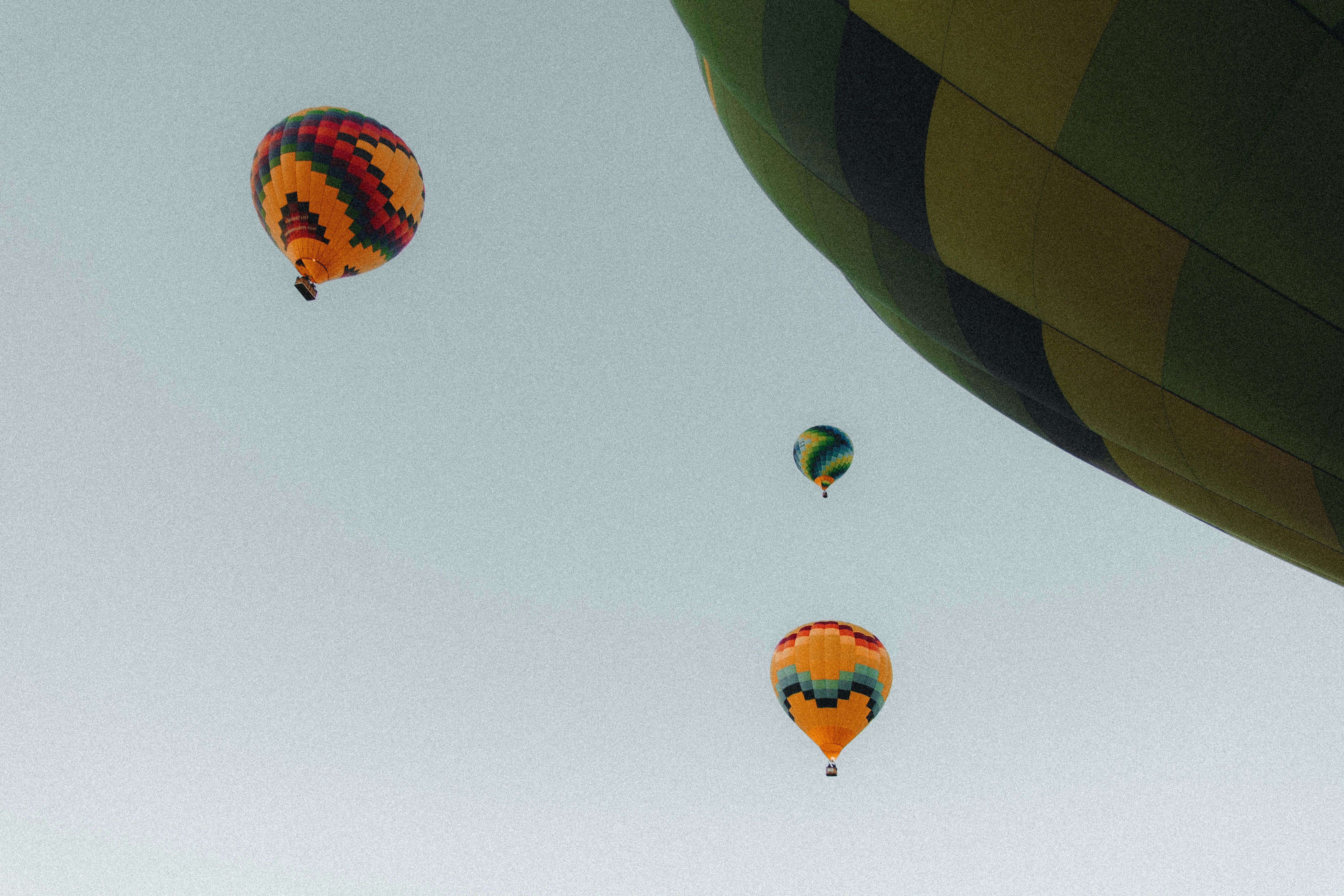 Quattro mongolfiere colorate che fluttuano in un cielo limpido e pallido