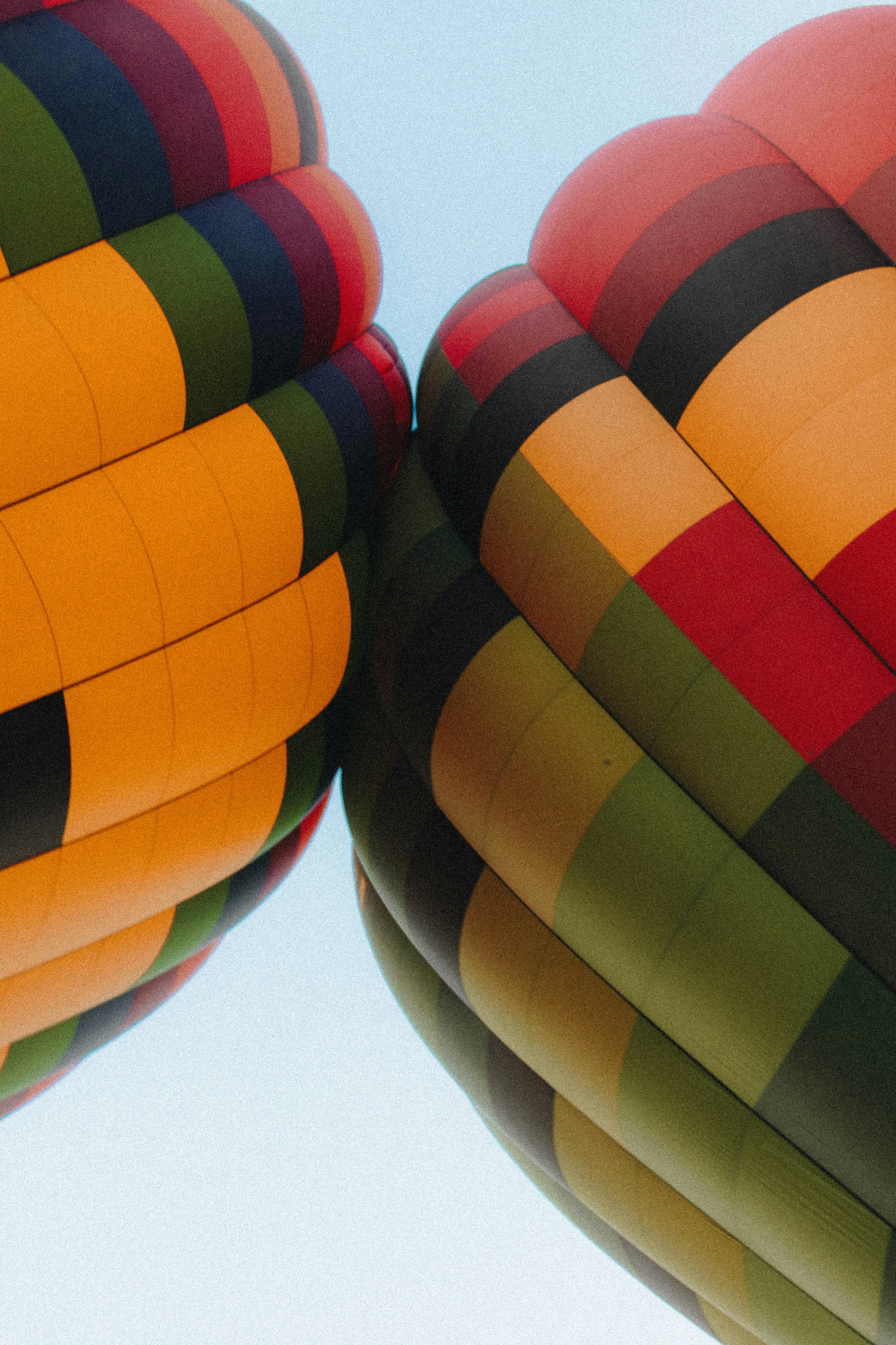 Due colorate buste di mongolfiera che si sfiorano contro un cielo azzurro limpido
