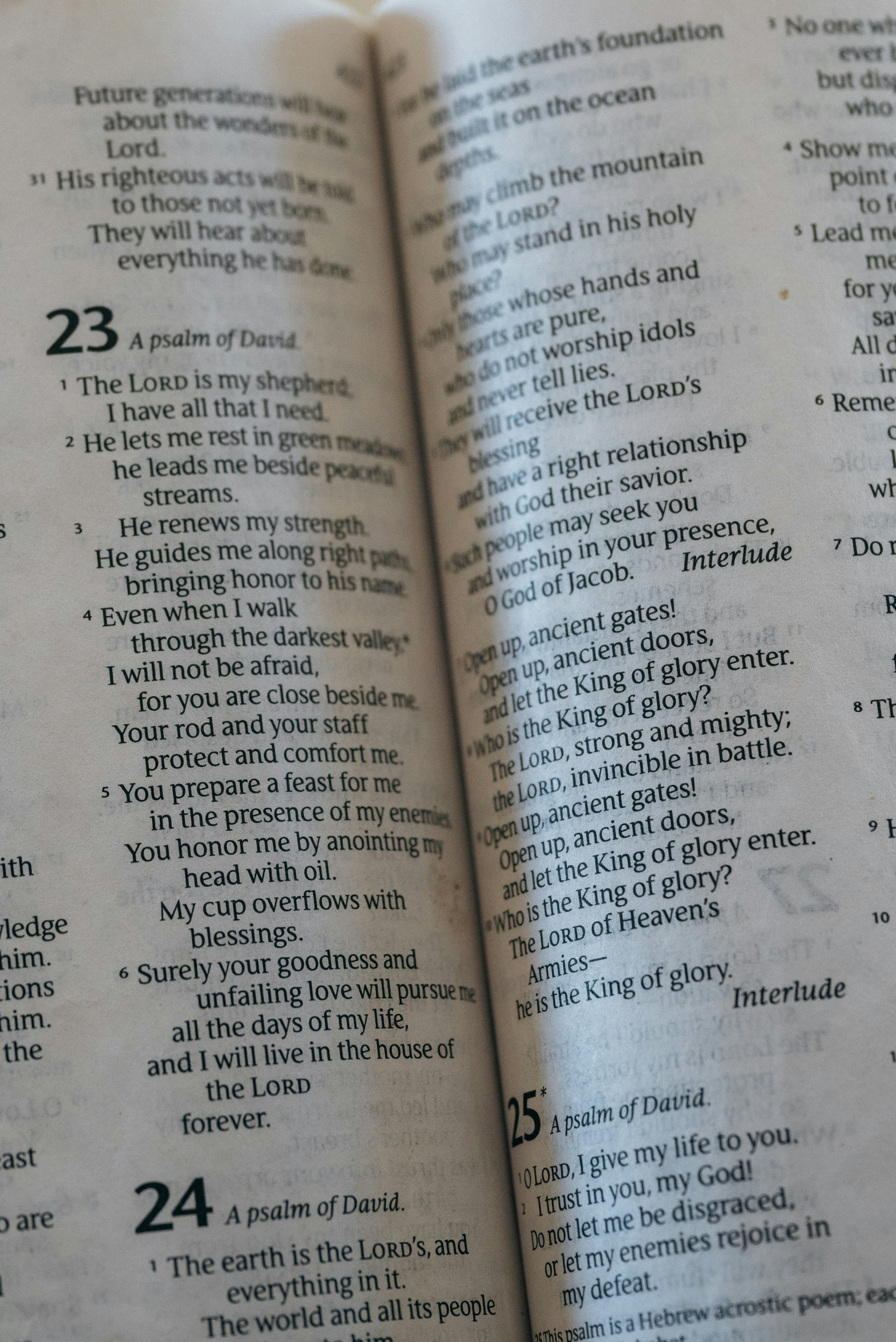 A close-up view of an open Bible page showing Psalm 23 and Psalm 24