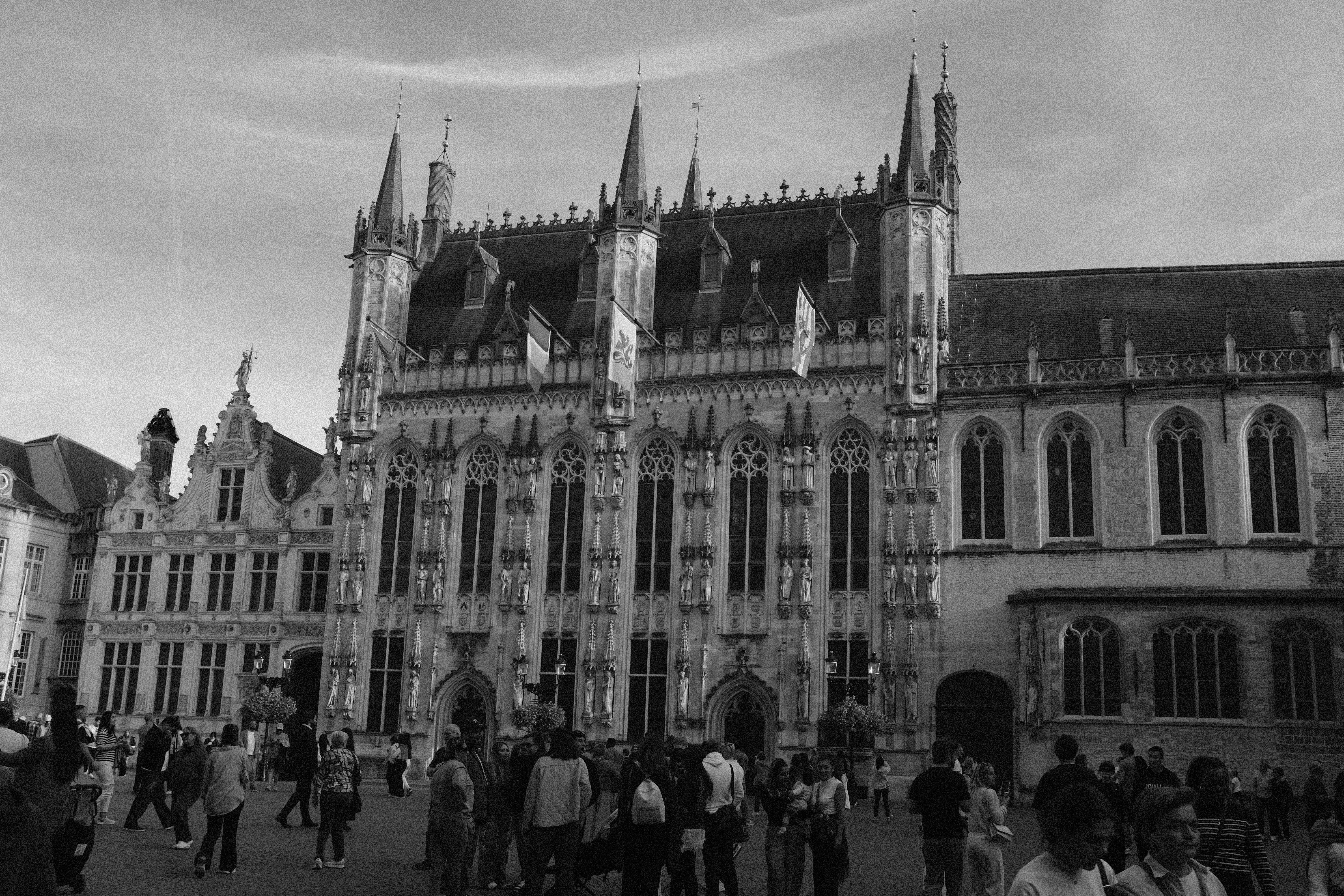 Crowd in Bruges Burg Square in front of the Gothic Brugge City Hall facade