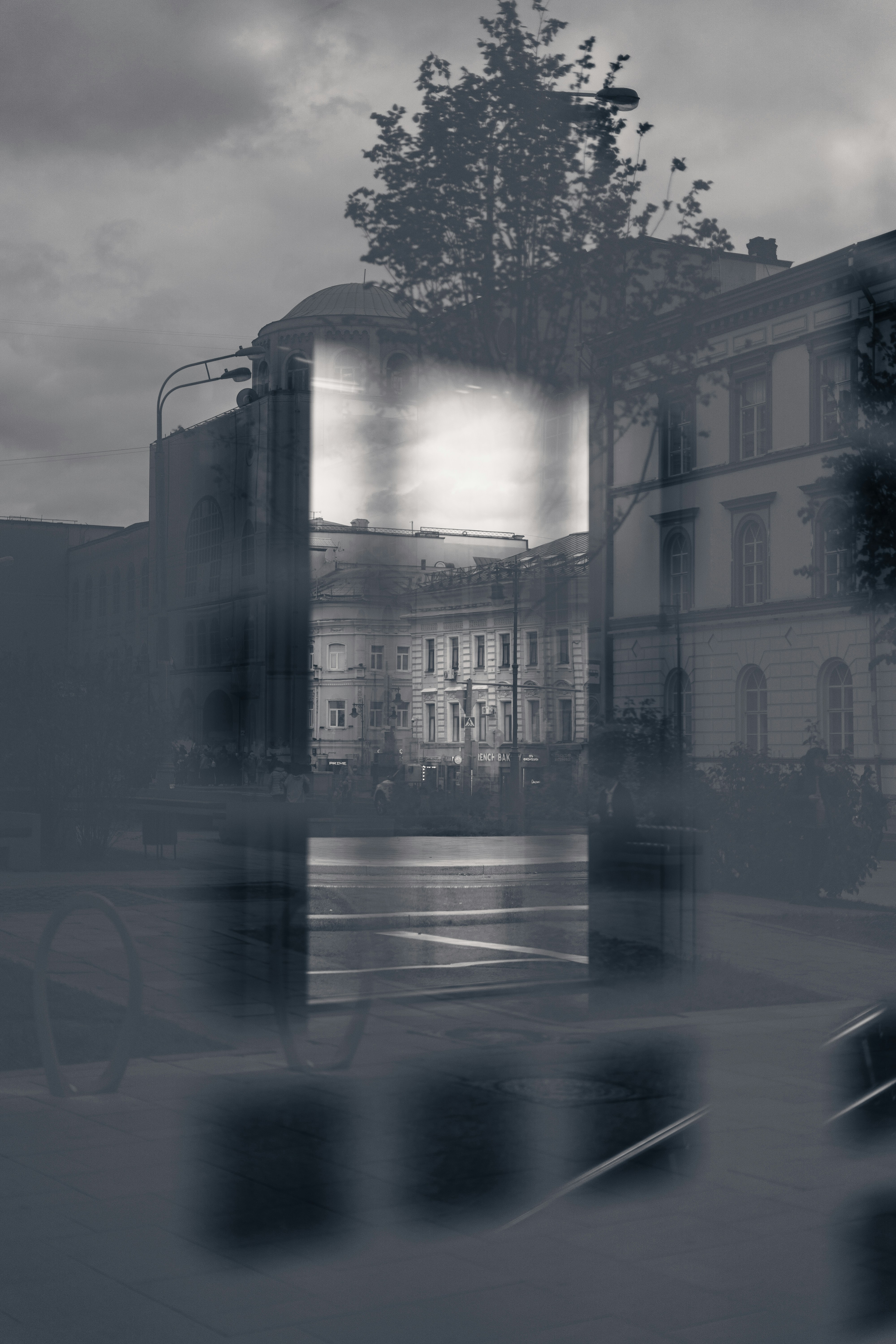 Une double exposition sur une rue de la ville avec des bâtiments historiques et un grand arbre