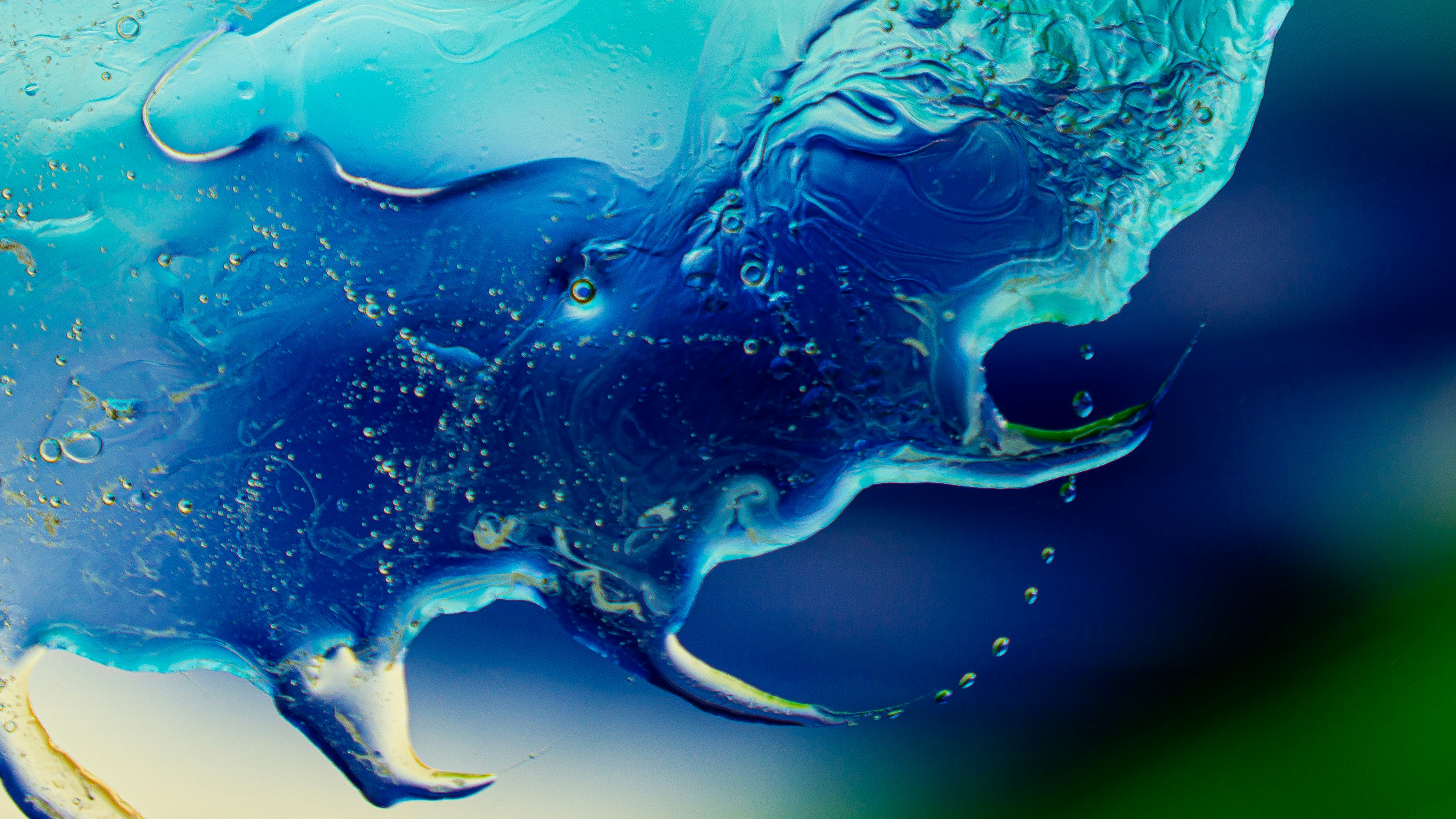 Macro view of viscous blue liquid swirling with bubbles against a dark background