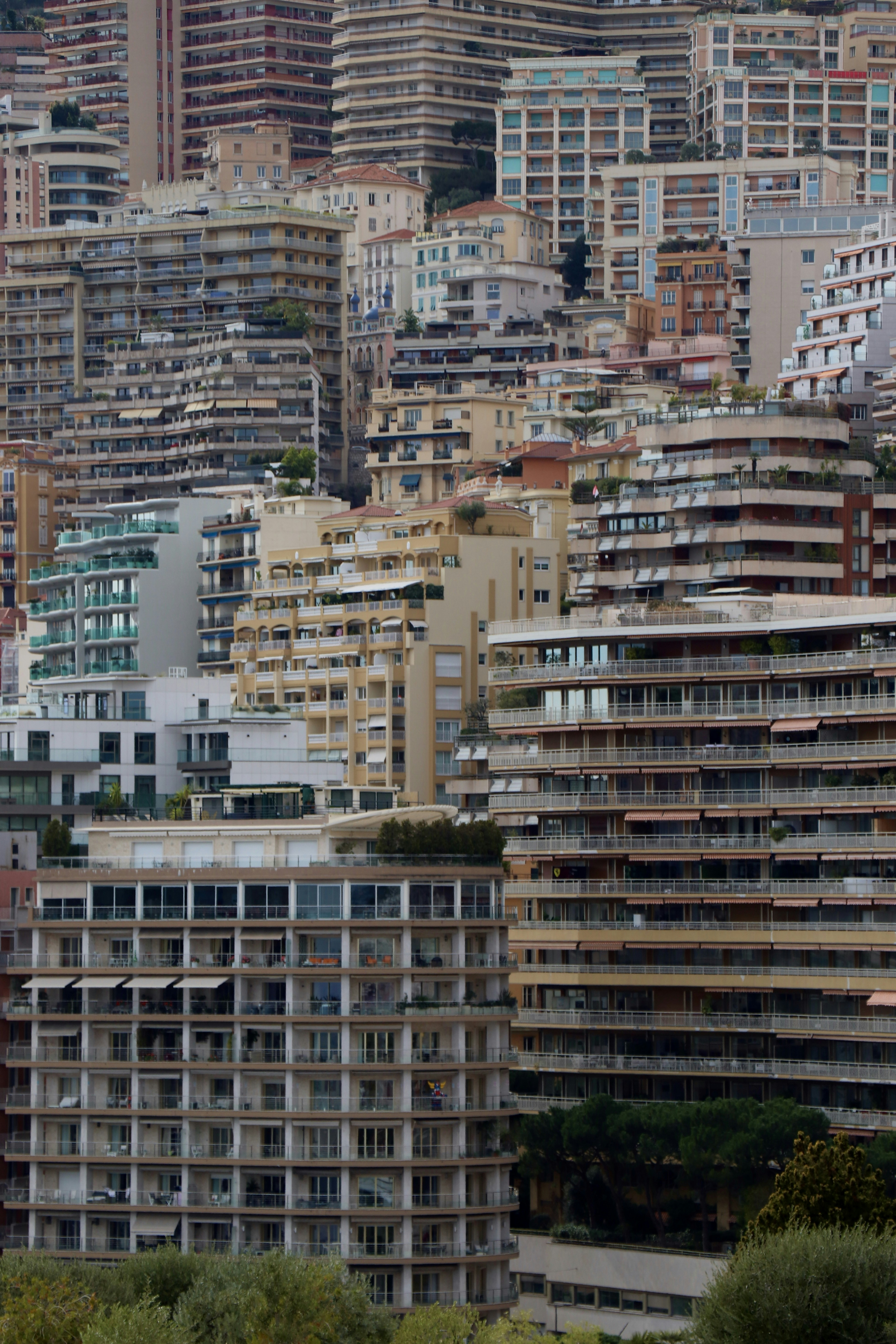 Dense residential apartment buildings with balconies stacked on a hillside in Monaco