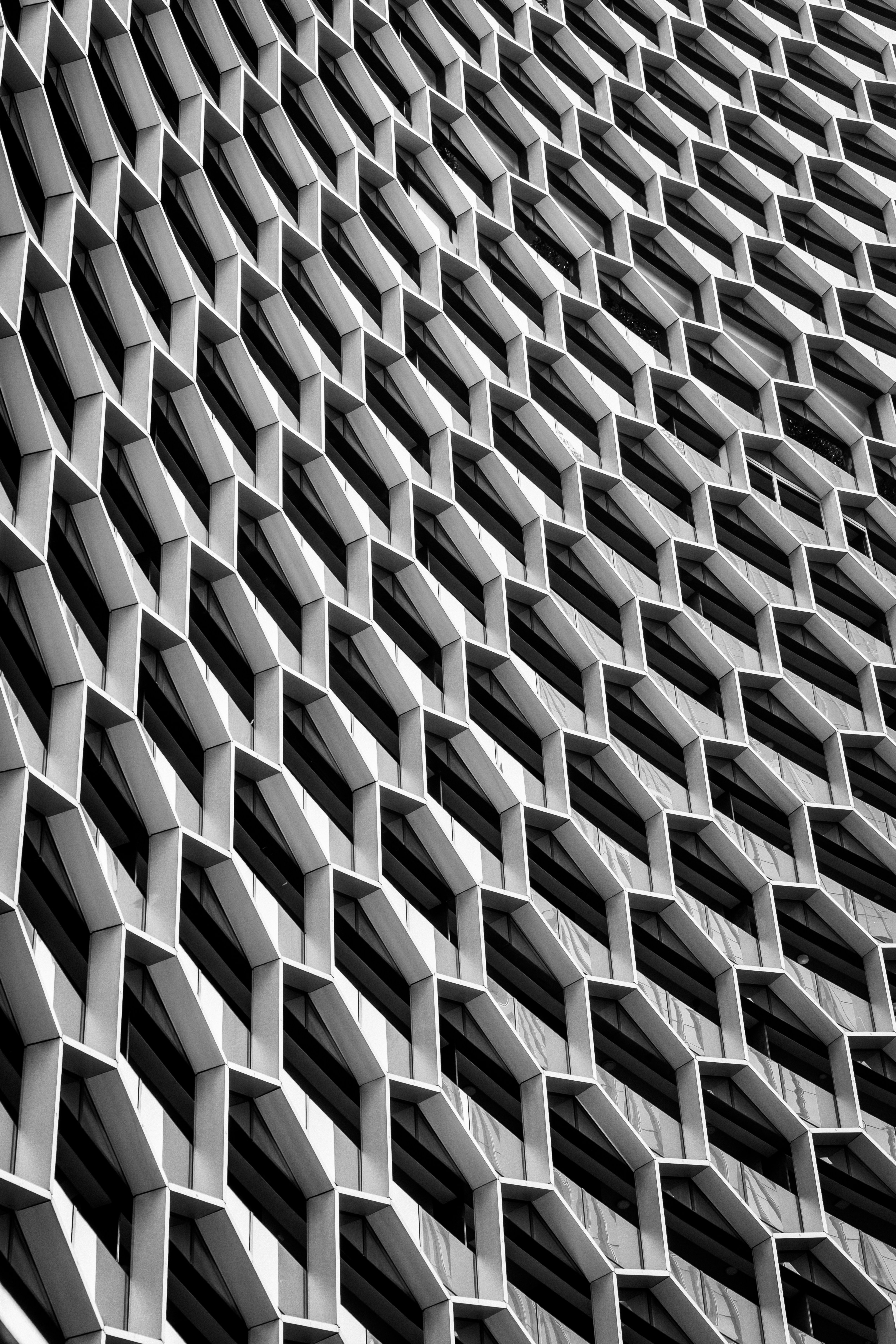 Gros plan noir et blanc d’une façade de bâtiment avec un motif hexagonal répétitif en nid d’abeille