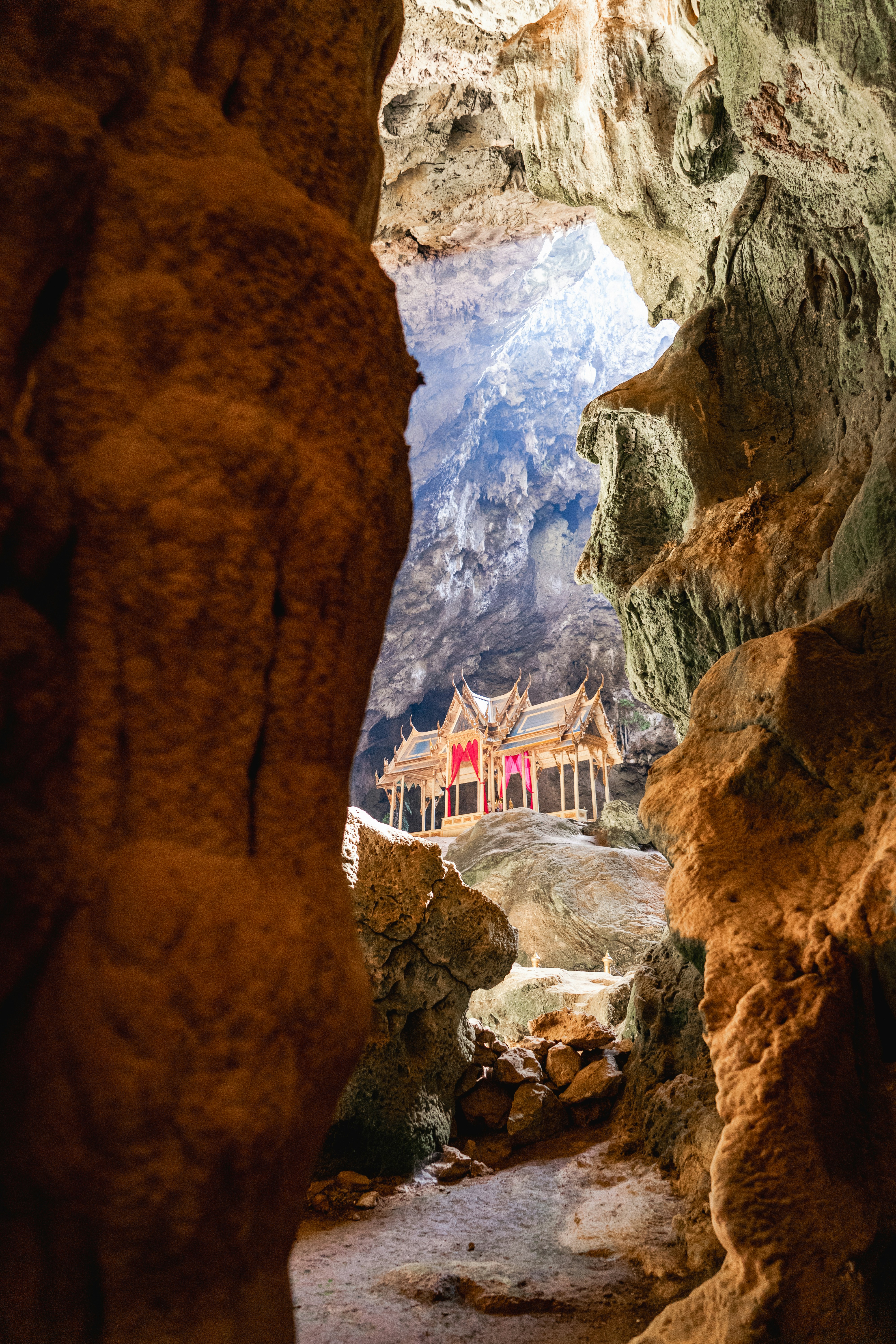 Un pavillon thaïlandais traditionnel à l’intérieur d’une grande grotte calcaire éclairée par la lumière naturelle venant d’en haut