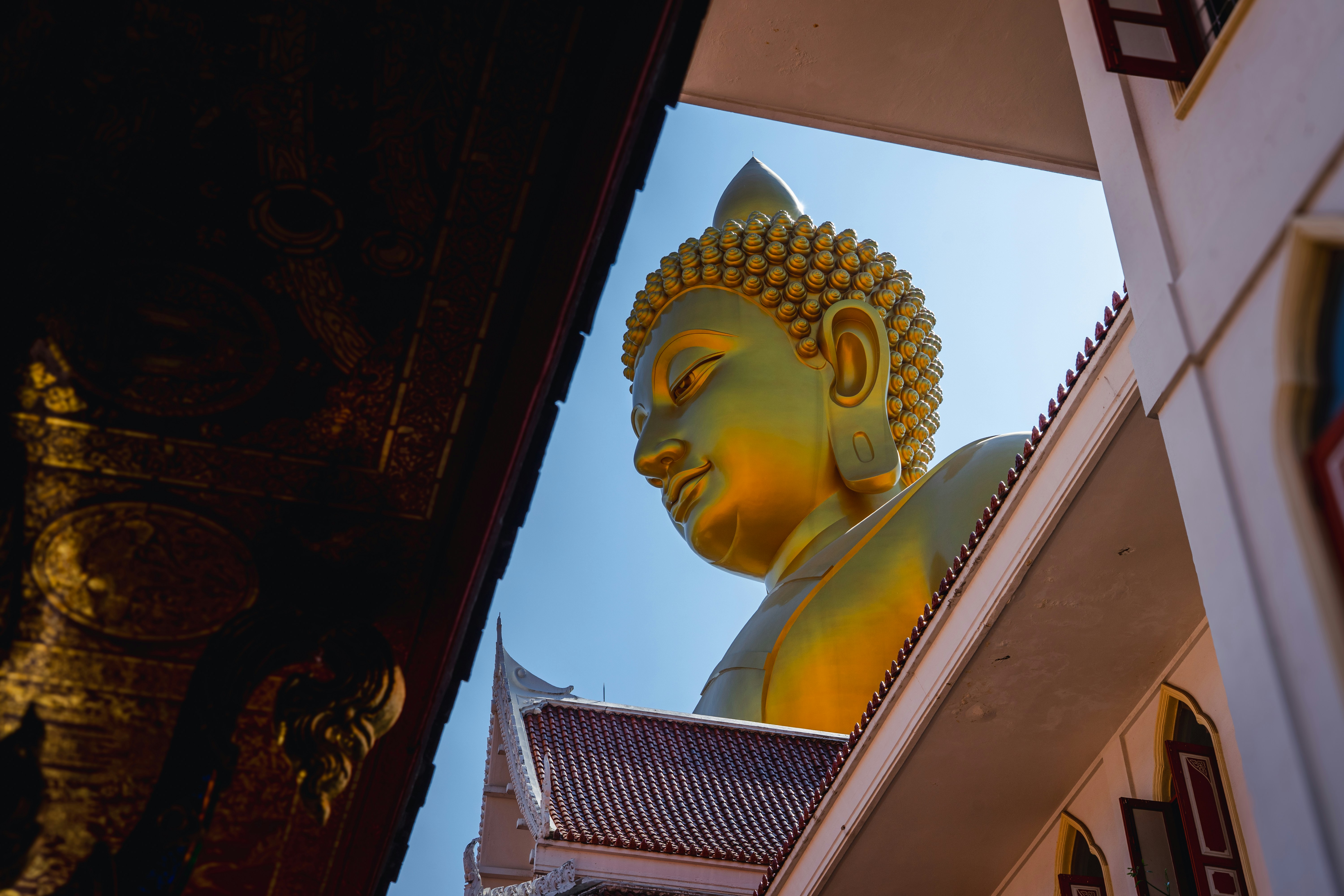 Une statue géante de Bouddha dorée vue depuis deux temples à Bangkok, en Thaïlande