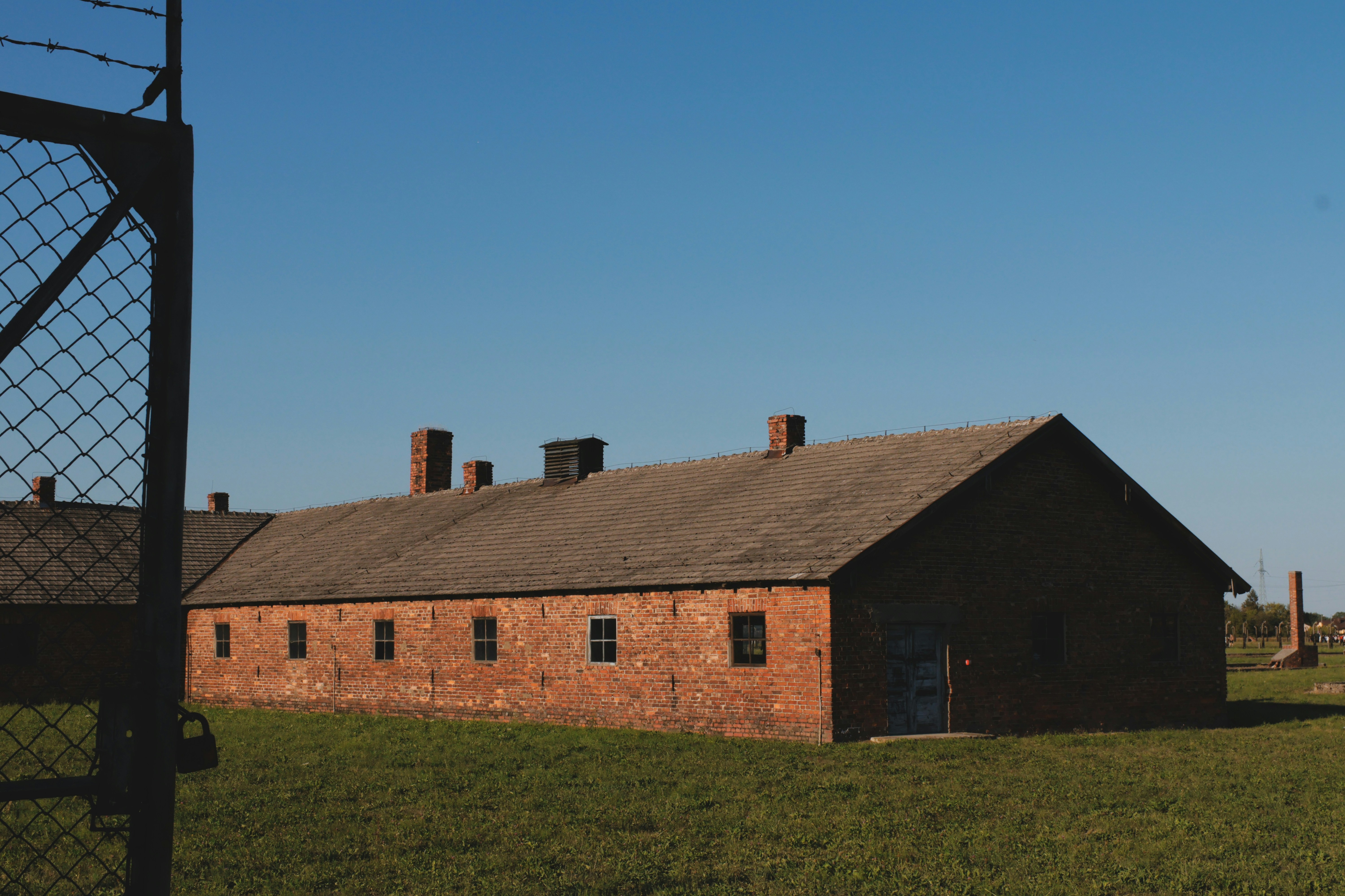 Red brick building behind wire fence - Free Photo on Unsplash