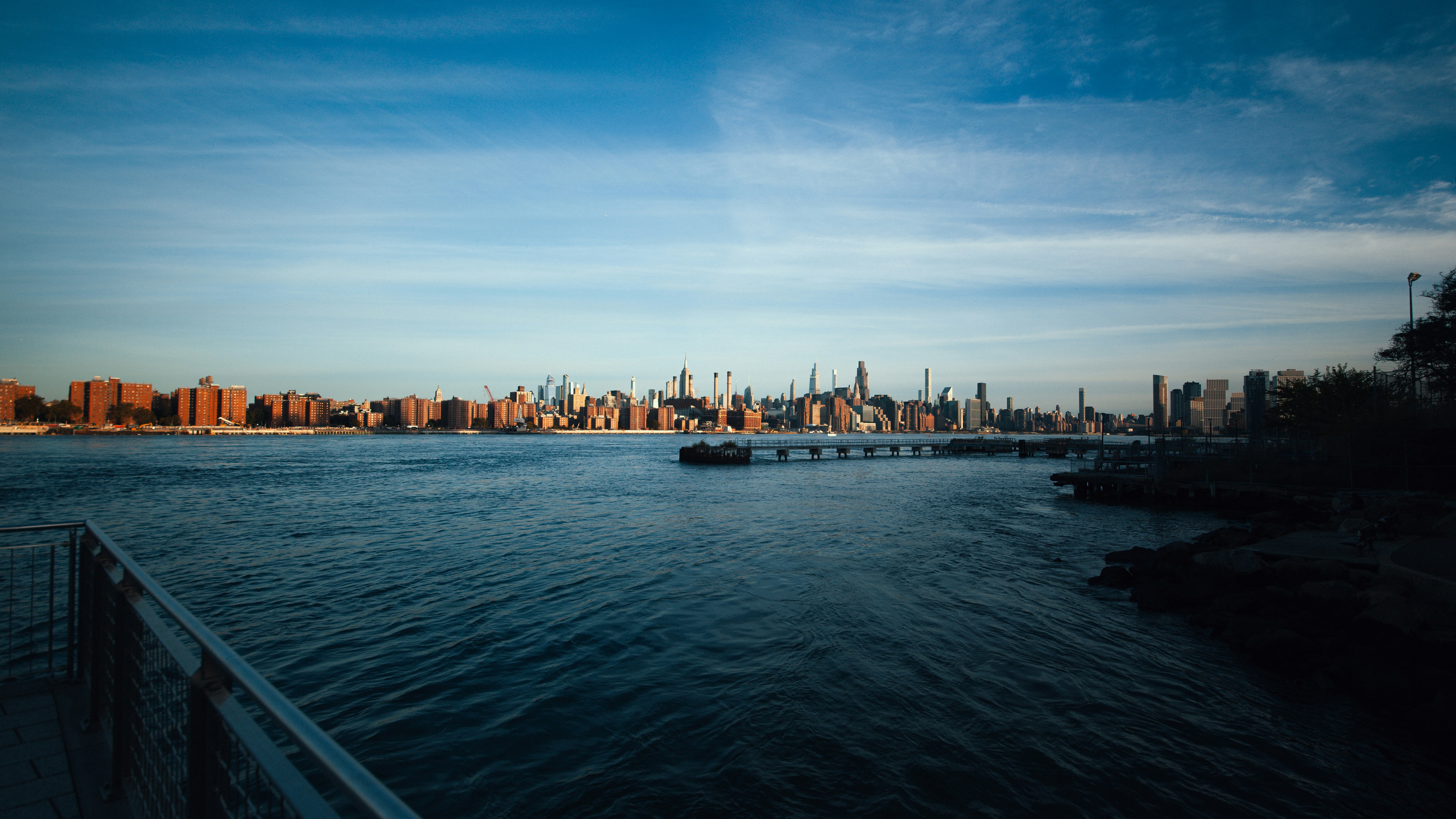 The Manhattan skyline across the East River under a clear blue sky in New York