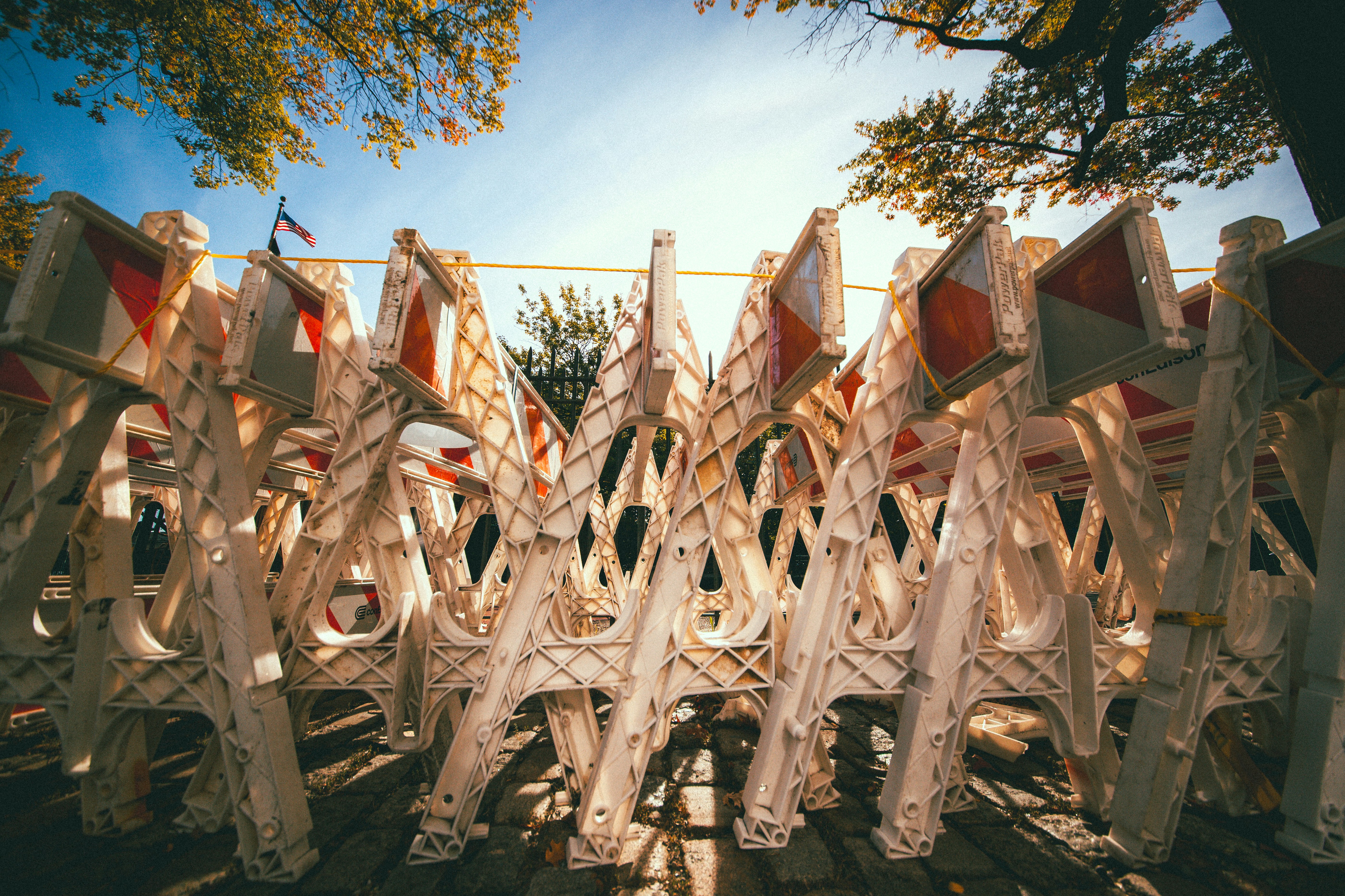 A stack of white plastic construction barriers with orange and white reflective panels in New York